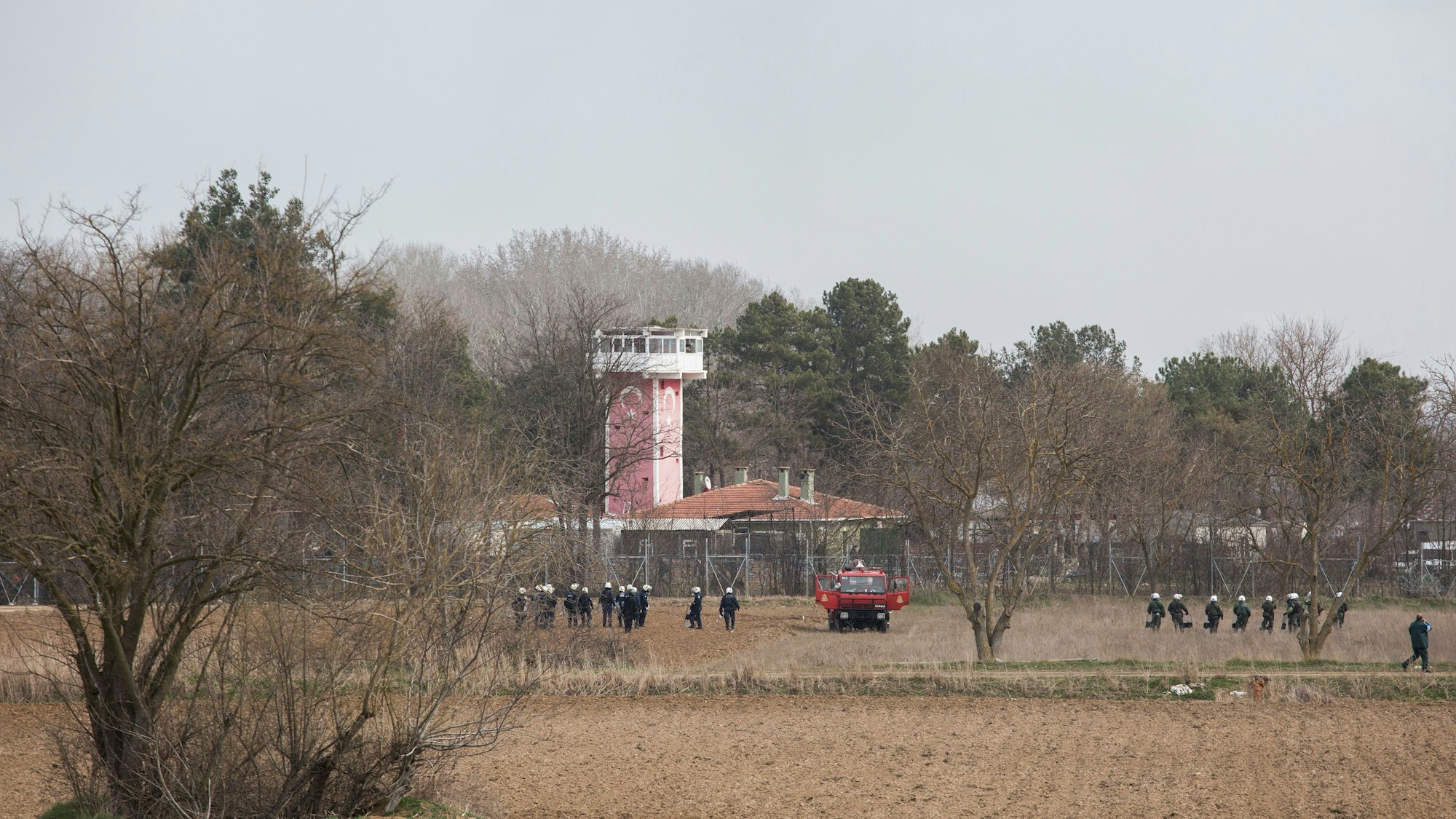 Griechische Sicherheitskräfte stehen mit Helmen und Schutzschilden ausgerüstet am Grenzzaun zur Türkei. (Symbolbild)