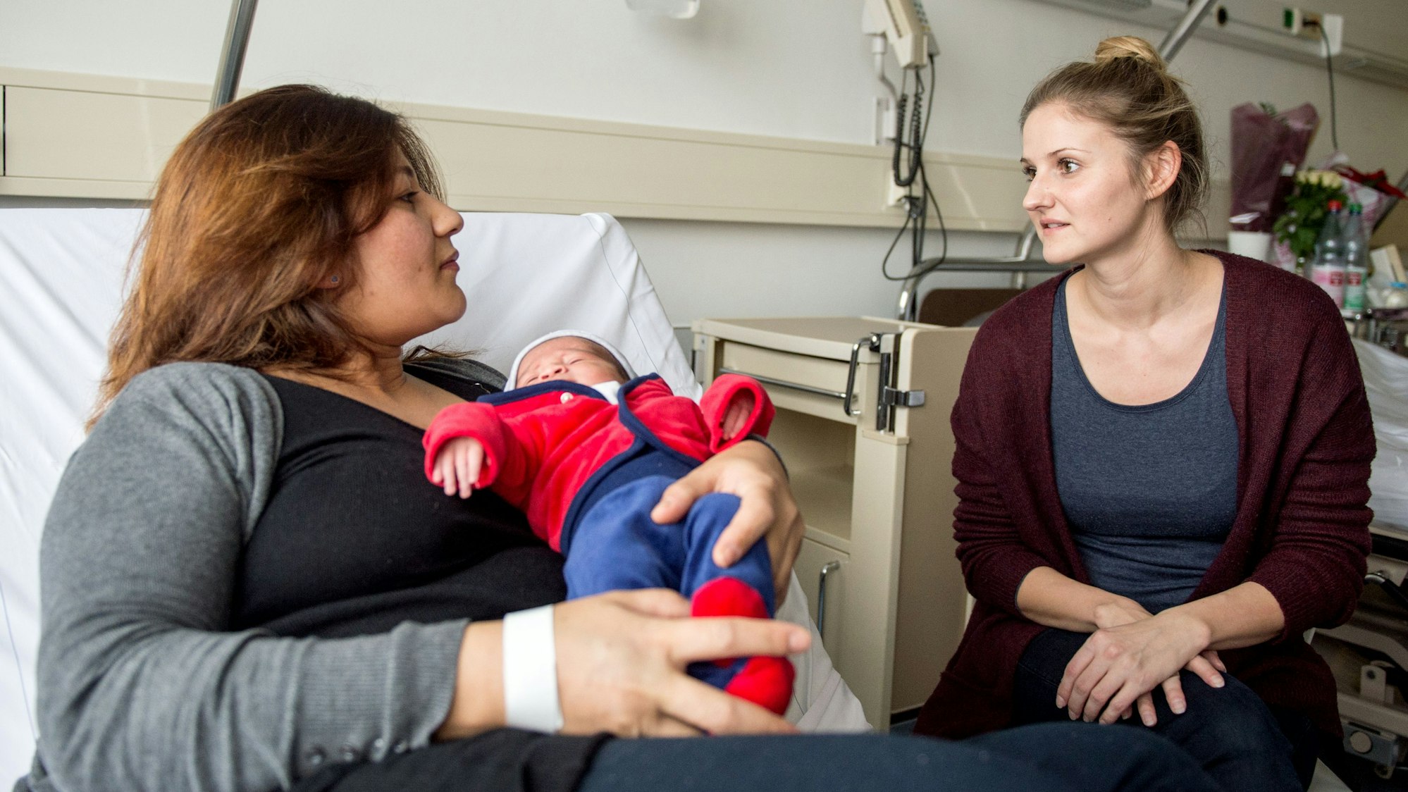 Babylotsin Anne Mellinger (rechts) unterhält sich mit Mutter Makai Tukhy, die ihr Neugeborenes auf dem Arm hält.