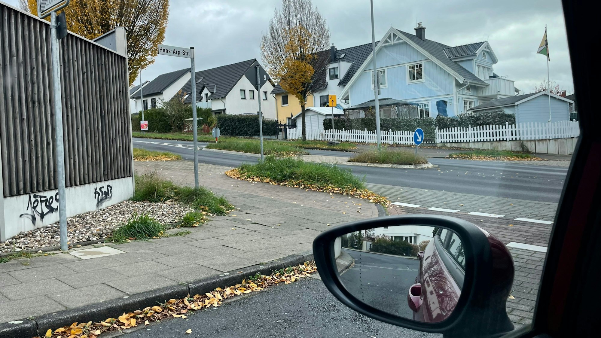 Blick aus einem Autofenster auf den Radweg, der die Hans-Arp-Straße kreuzt.