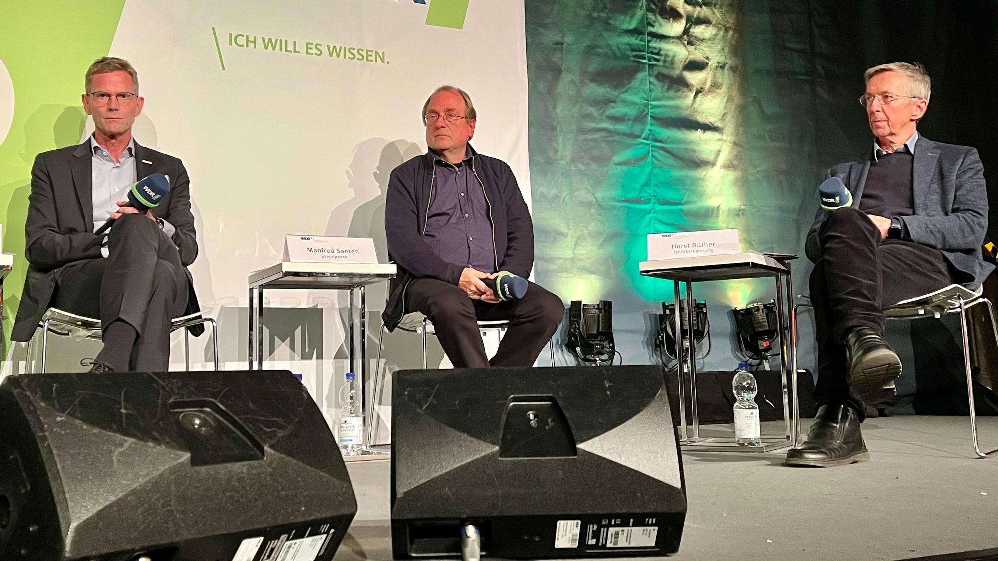 Hans Gennen, Technikchef von Currenta, Manfred Santen, Chemiker bei Greenpeace, und Horst Büther von der Bezirksregierung Köln sitzen auf einem Podium im Opladener Scala