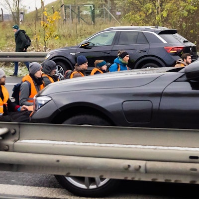 Teilnehmer eines Klimaprotests blockieren auf der A113 kurz vor der Ausfahrt zum Flughafen Berlin Brandenburg (BER)