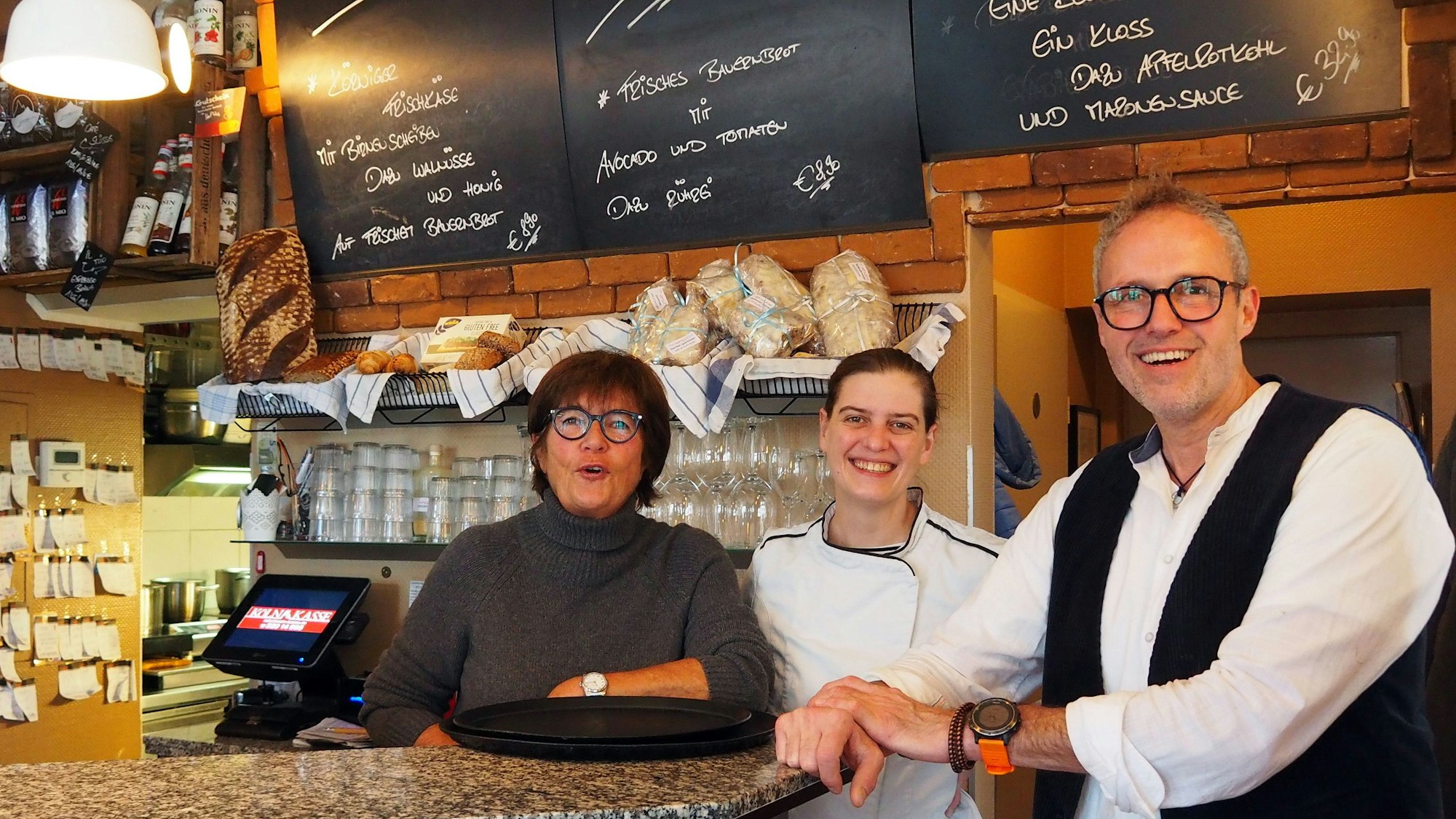 Brigitte Breiter (Köchin), Esther Raderberger und Olaf Schlien (Inhaber) im Café Haptilu im Kartäuserhof hinter der Theke.