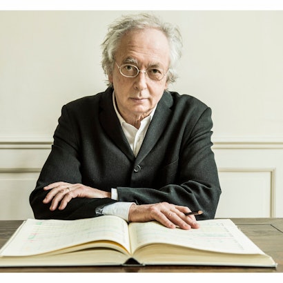 Der flämische Dirigent Philippe Herreweghe. Er trägt ein weißes Hemd und darüber einen schwarzen Mantel