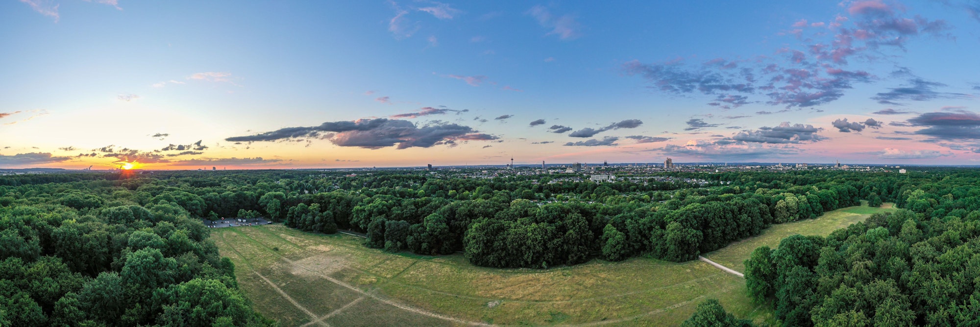 Das Panoramabild zeigt den Blick über die Gleueler Wiese im Äußeren Grüngürtel, während im Hintergrund das Stadtzentrum Kölns zu sehen ist.