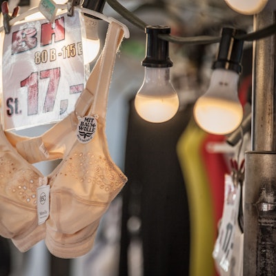 Ein fleischfarbener BH hängt an einem Marktstand.