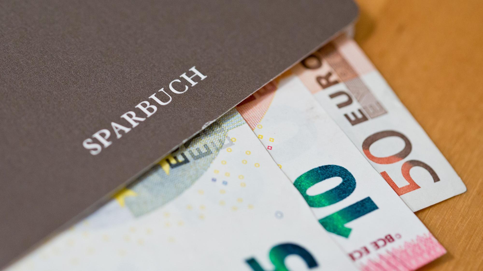 Euro-Geldscheine liegen in einem Sparbuch.