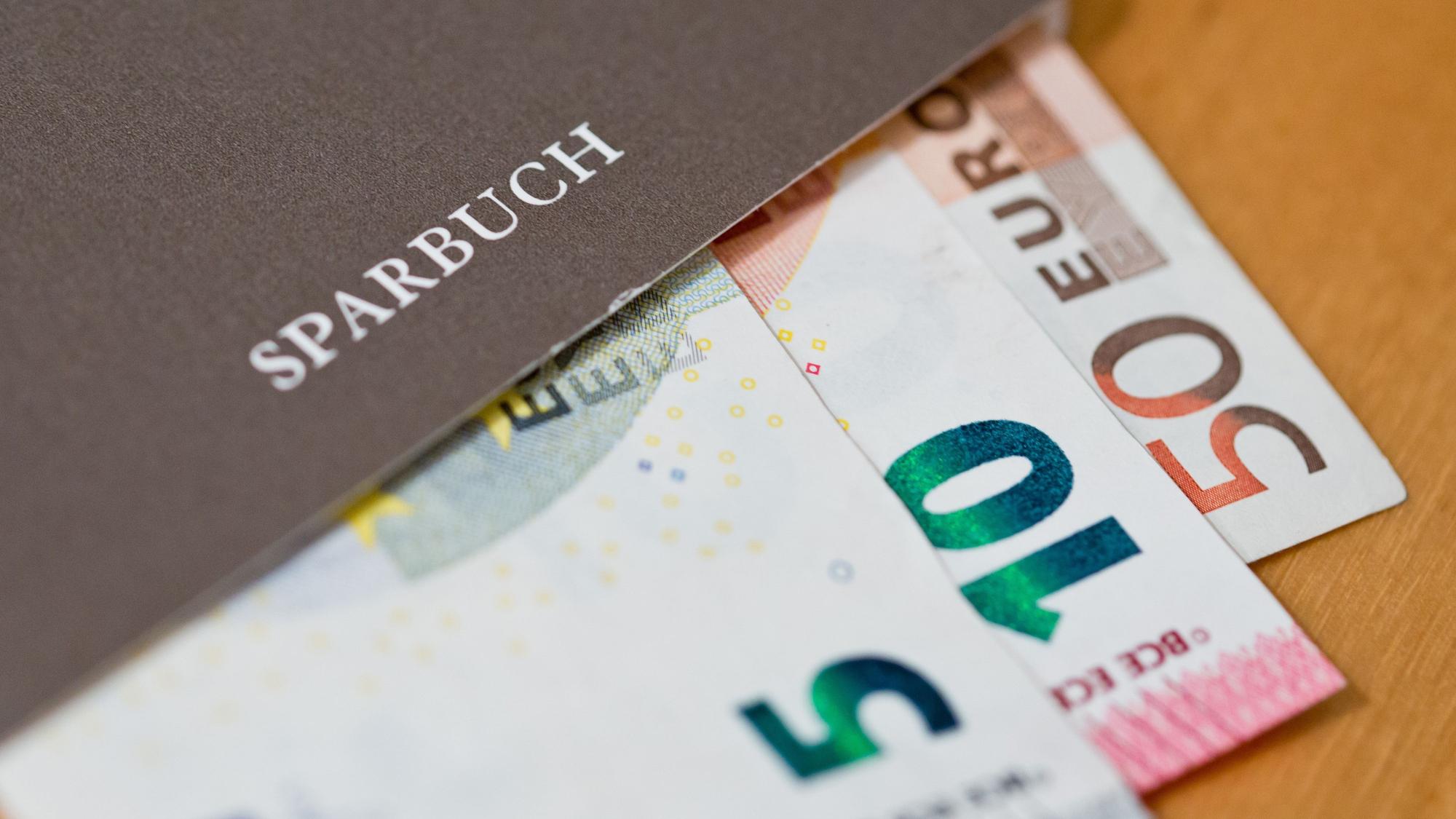 Euro-Geldscheine liegen in einem Sparbuch.