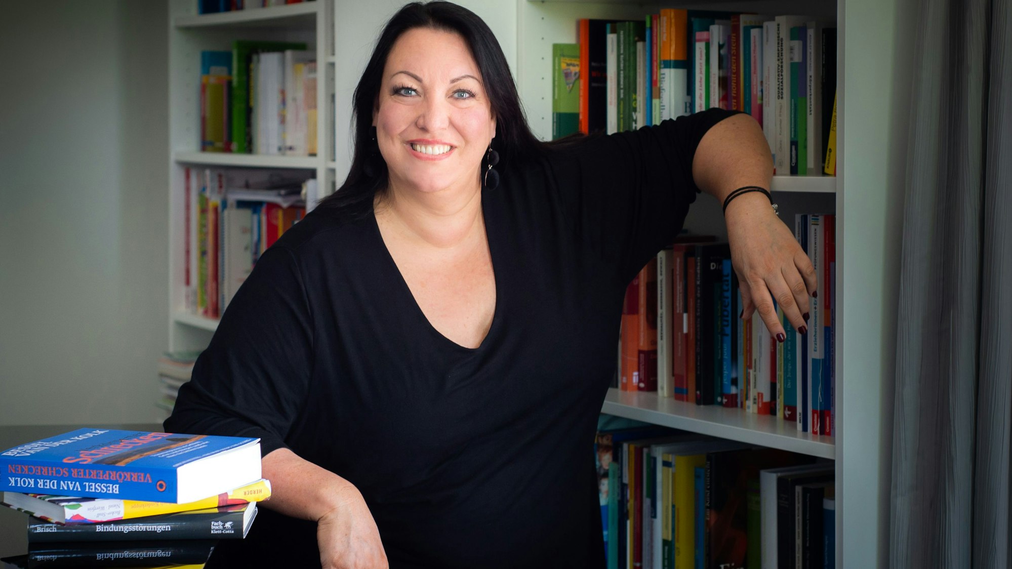 Die Psychologin und Pädagogin Anke Elisabeth Ballmann steht vor einem Bücherregal. Sie ist Expertin für gewaltfreie Pädagogik und hat das Institut „Lernmeer“ sowie die „Stiftung Gewaltfreie Kindheit“ gegründet.