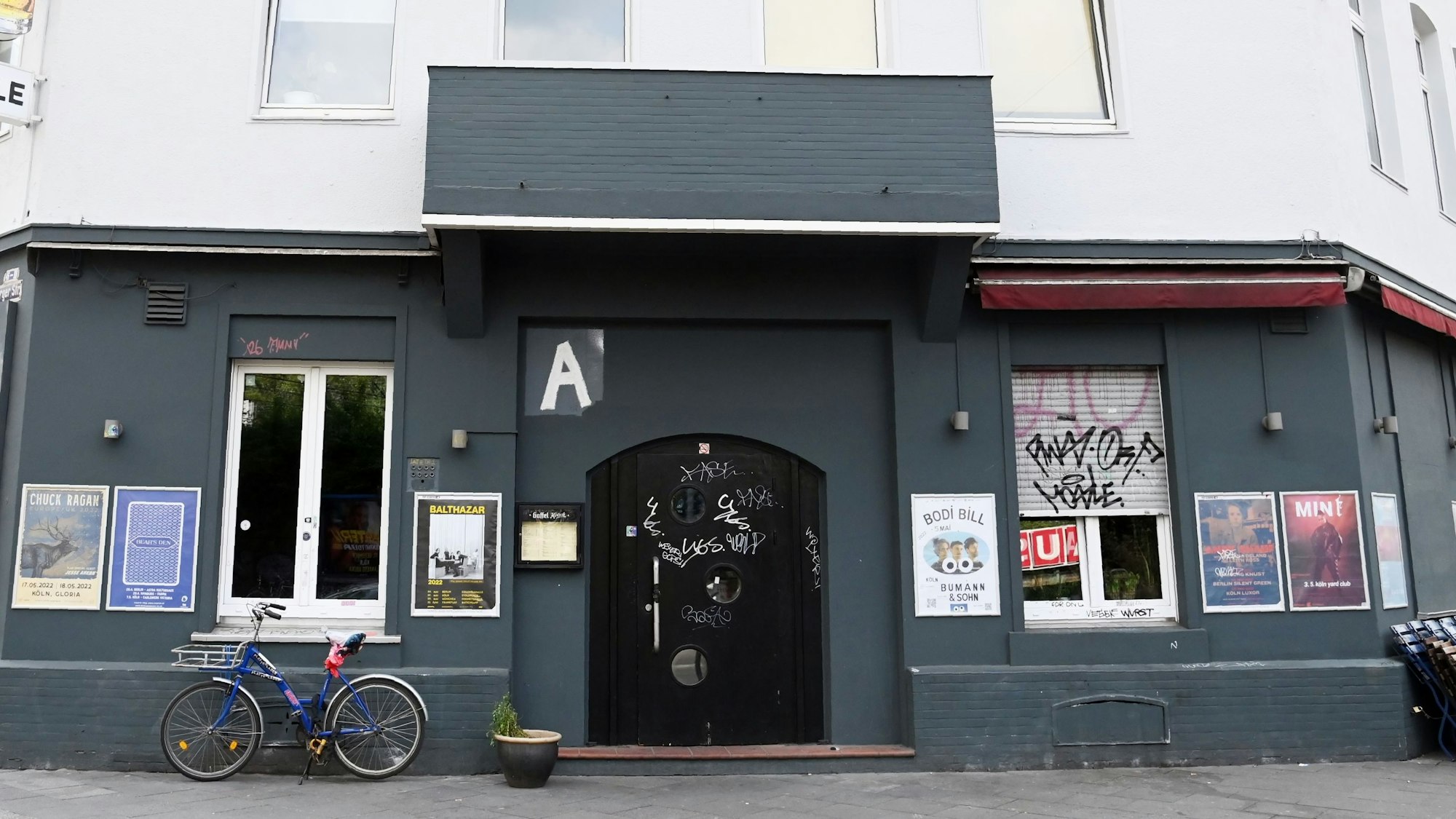 Das Acephale von Außen: die schwarze Fassade ziert ein aufgepinseltes A über der Tür.