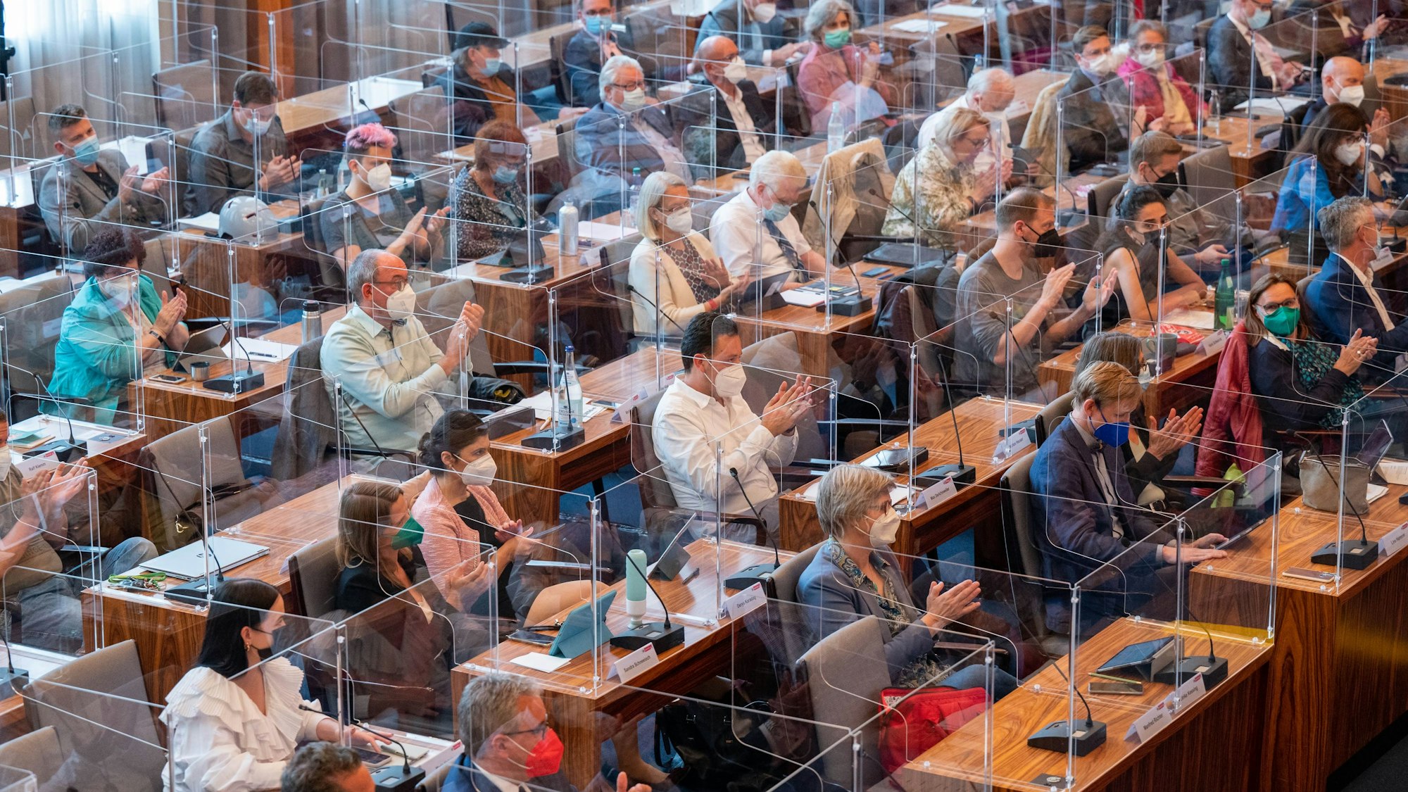 Ratsmitglieder applaudieren im Stadtrat.