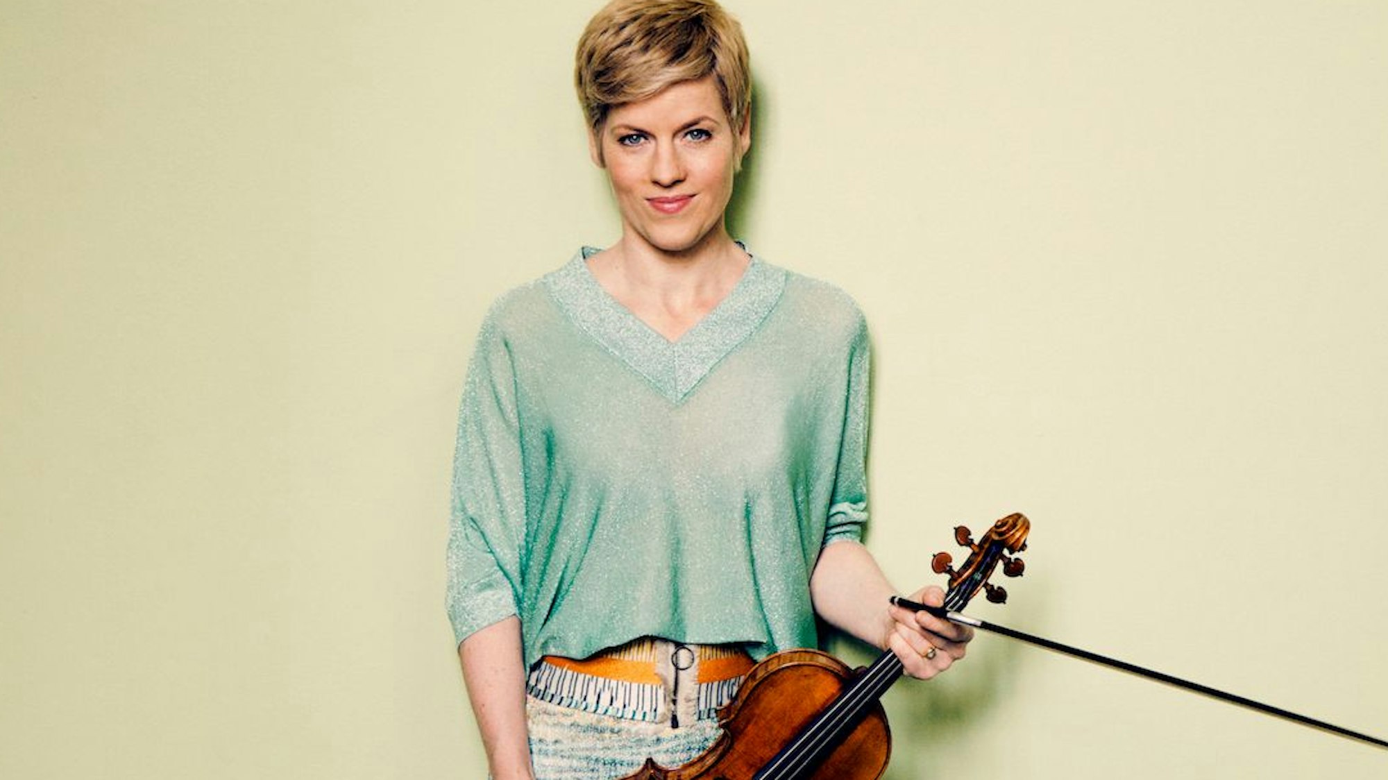 Isabelle Faust
hält eine Violine in der Hand.