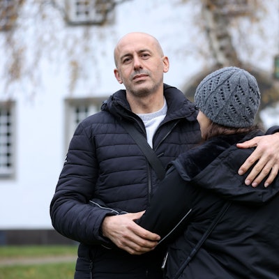 Tammam Zeno, Familienvater aus Syrien, hält seine Tochter Ritta im Arm. Von Ritta ist nur der Rücken zu sehen, sie möchte nicht erkannt werden. Die beiden fanden Unterschlupf im Kirchenasyl in Köln.