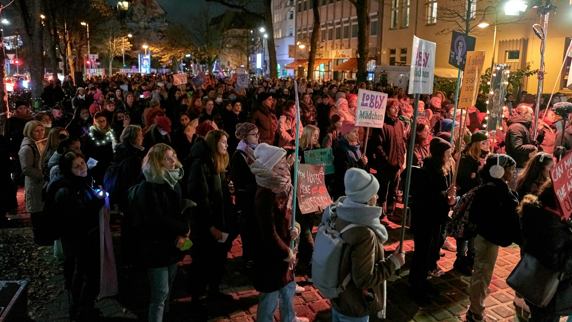 Teilnehmerinnen und Teilnehmer der Protest-Veranstaltung „Wir nehmen uns die Nacht“ zum Internationalen Tag gegen Gewalt an Frauen stehen auf dem Hans-Böckler-Platz in Köln.