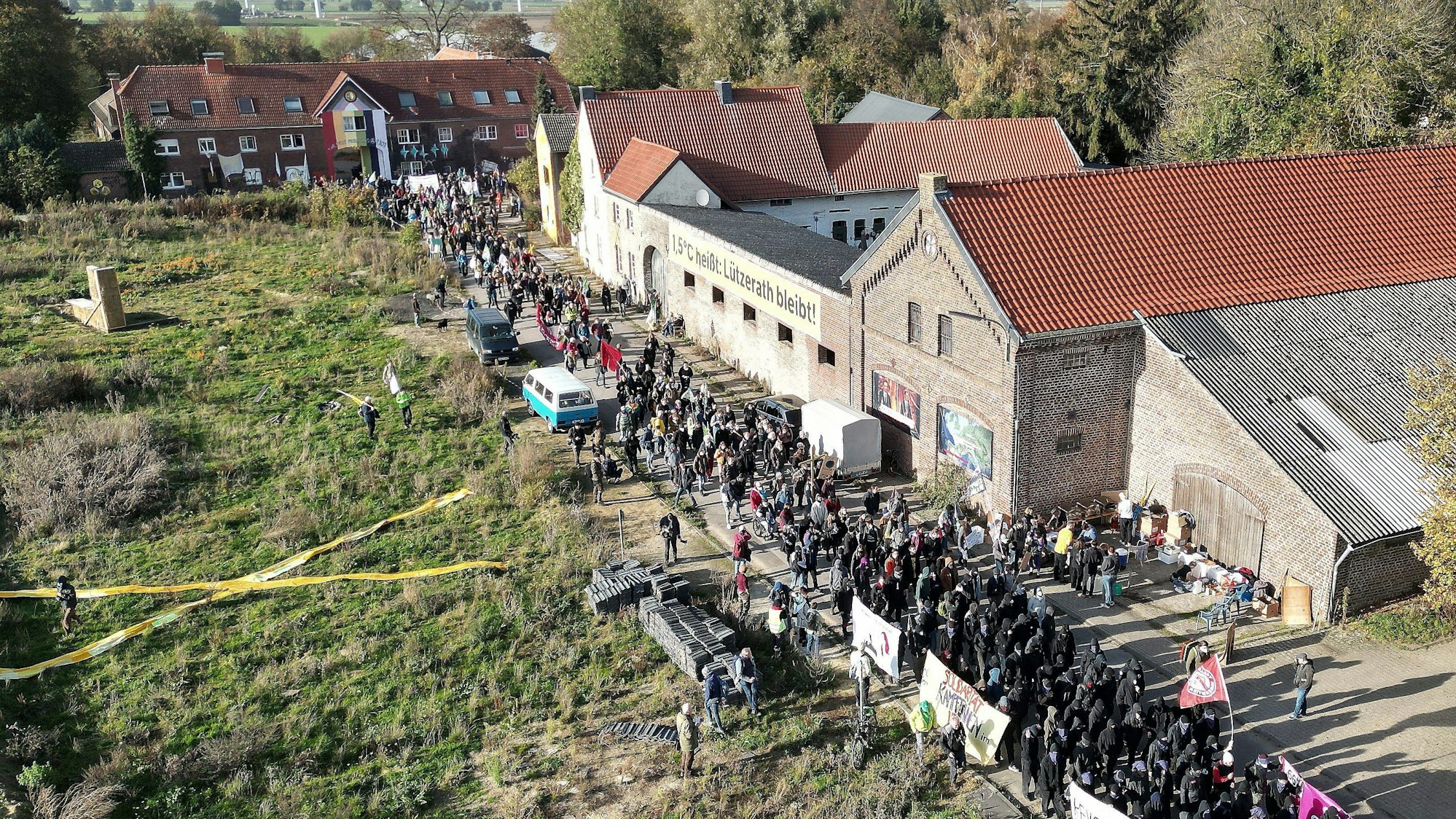 Bei einer Demonstration in Lützerath ziehen mehrere Hundert Teilnehmer mit Banner durch das Dorf.