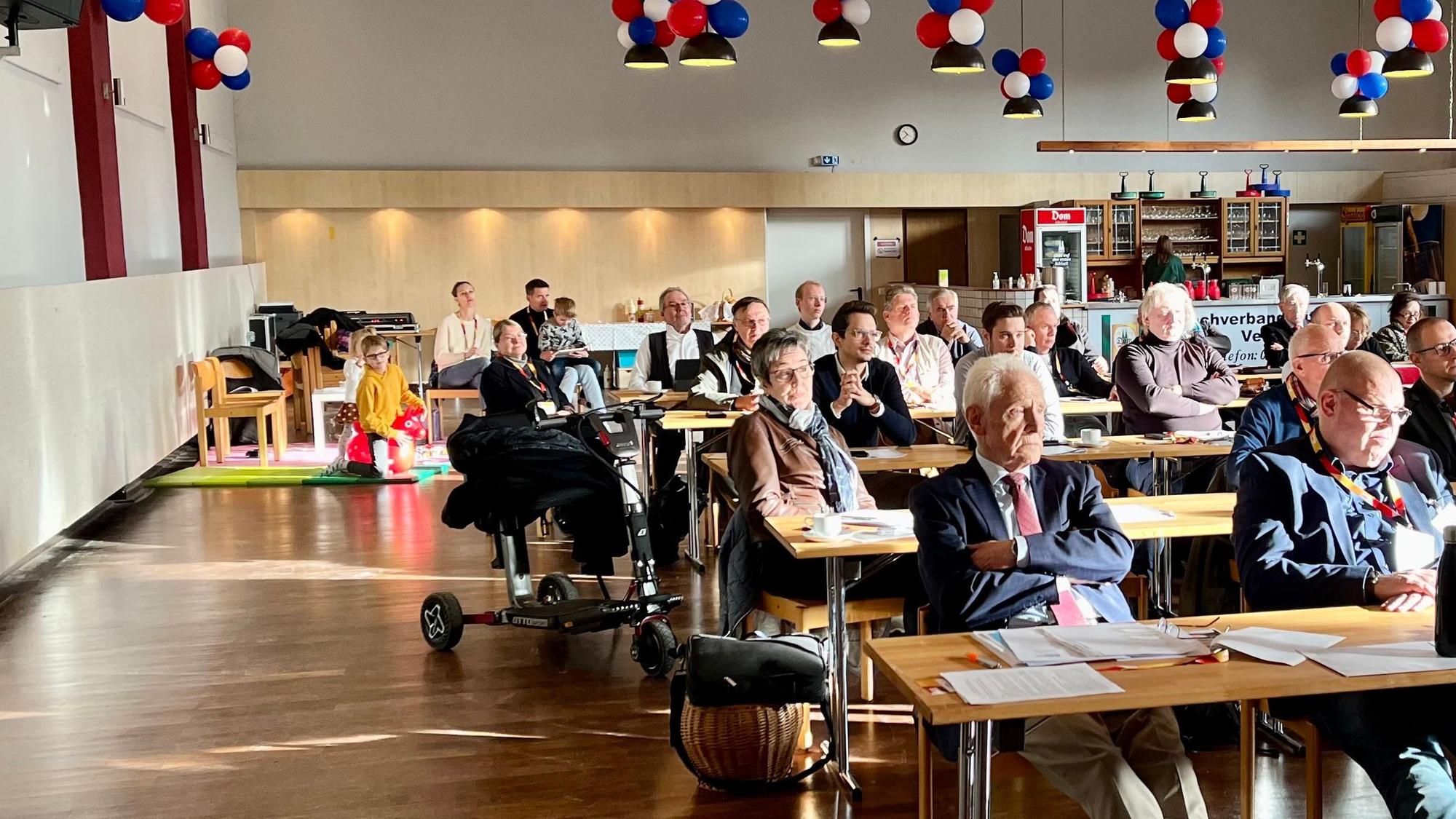 Die Stadthalle Hitdorf, gefüllt mit CDU-Mitgliedern und einer Spielecke für Kinder im Hintergrund