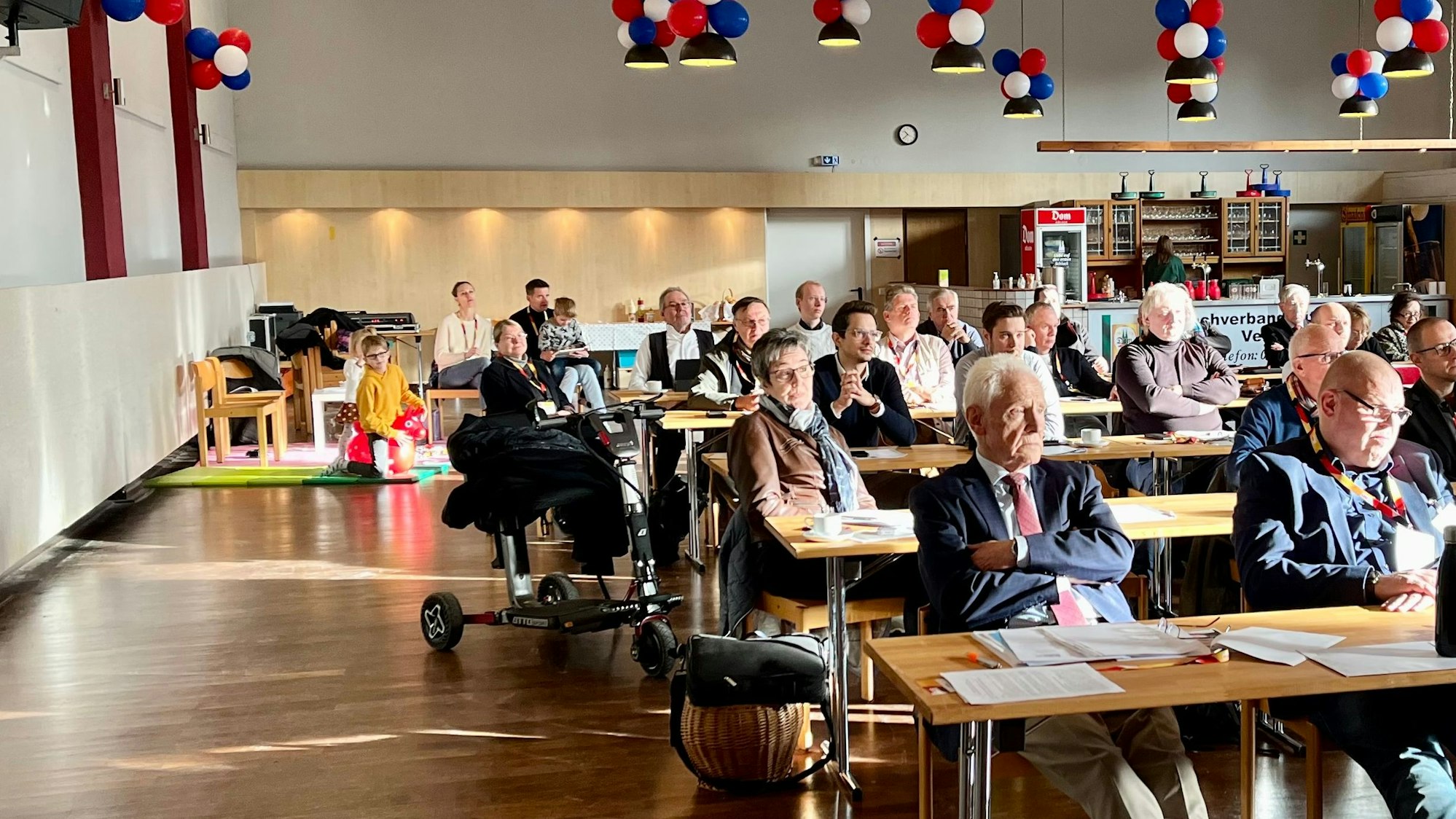 Die Stadthalle Hitdorf, gefüllt mit CDU-Mitgliedern und einer Spielecke für Kinder im Hintergrund
