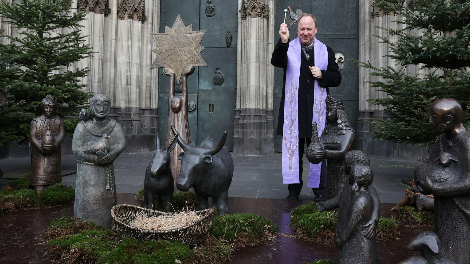 Domdechant Monsignore Kleine segnet die Kölner Stadtkrippe am Südportal des Kölner Doms.