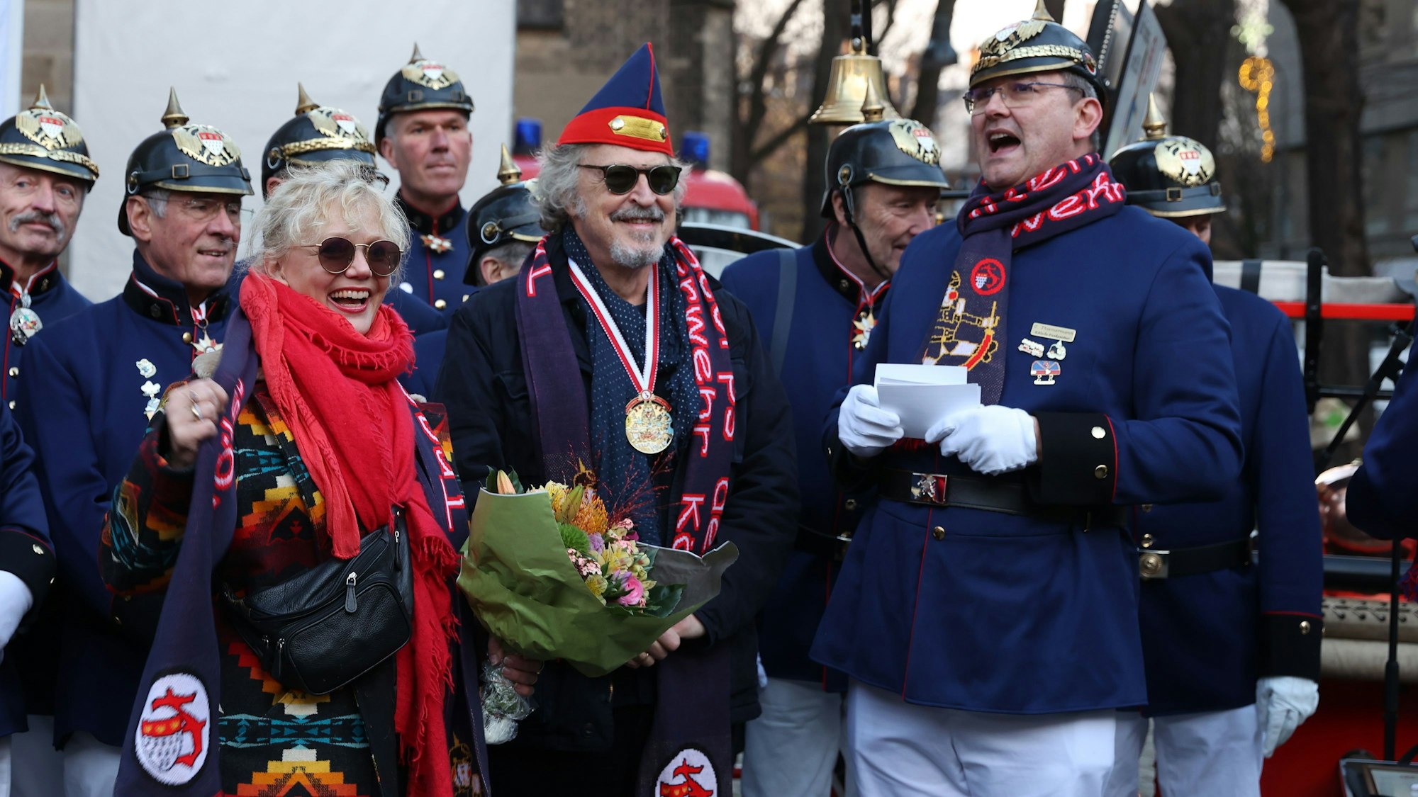 Wolfgang Niedecken wird von den Kölschen Funkentöter auf dem Severinskirchplatz der Titel Ehrenbrandmeister 2022 verliehen.
Seiner Frau Tina wird auch gedankt.