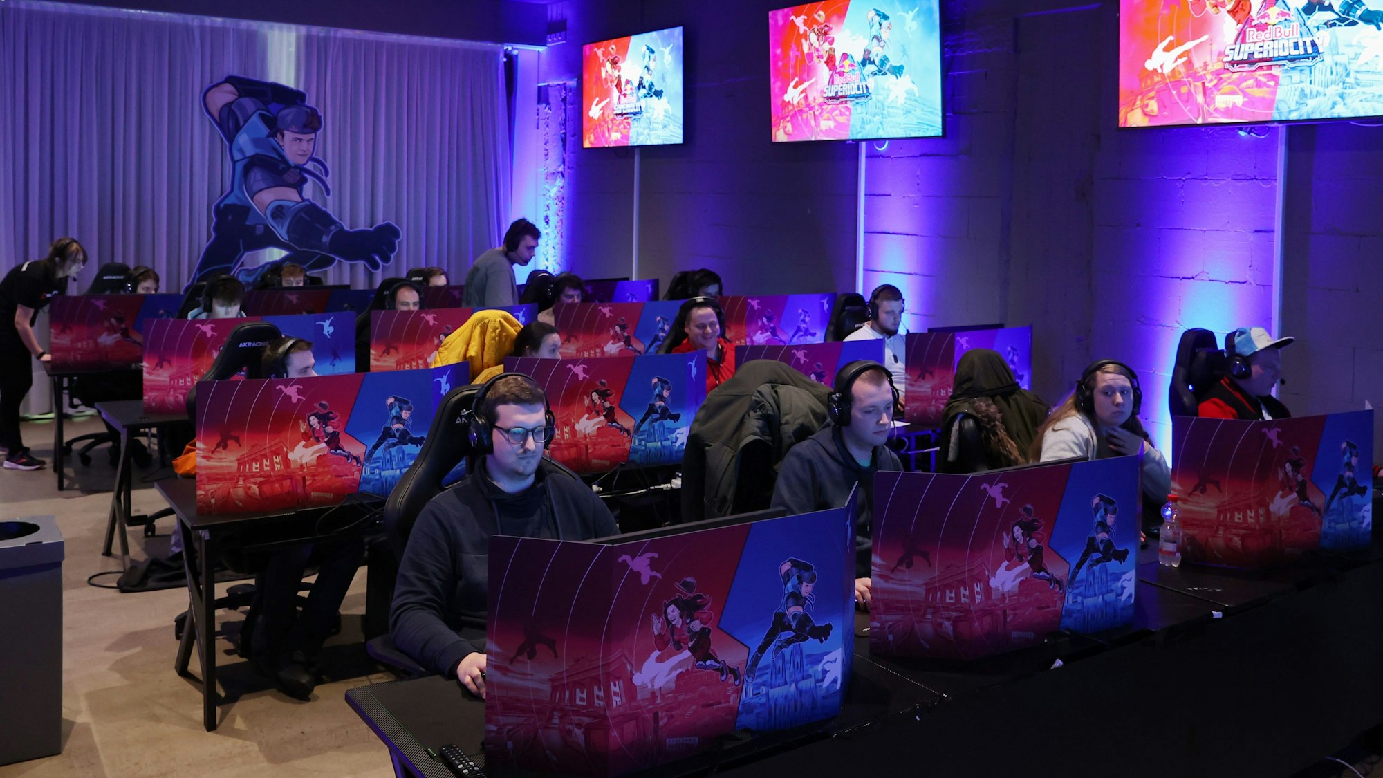 Das Bild zeigt Spieler des Kölner Teams, die im Xperion an PCs sitzen.