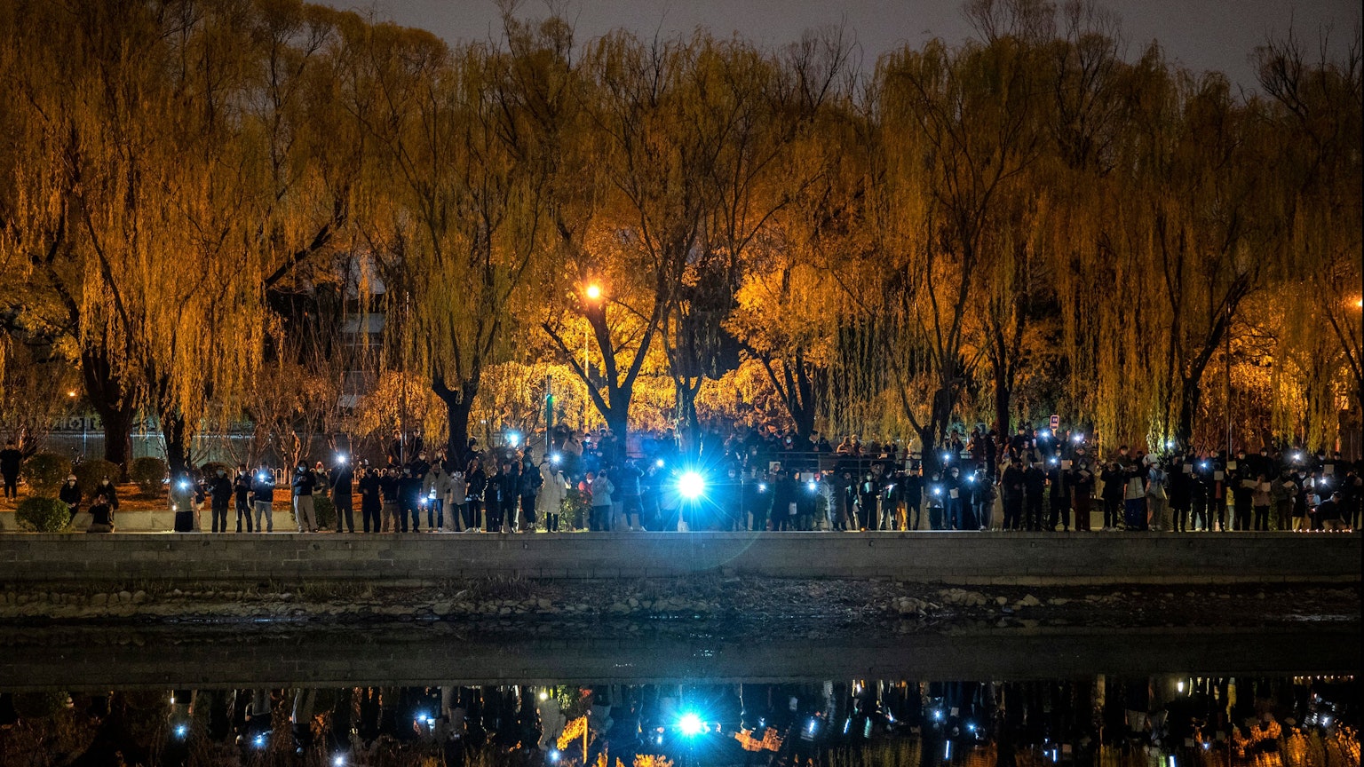 Protestierende in Peking halten ihre Handys in die Luft.
