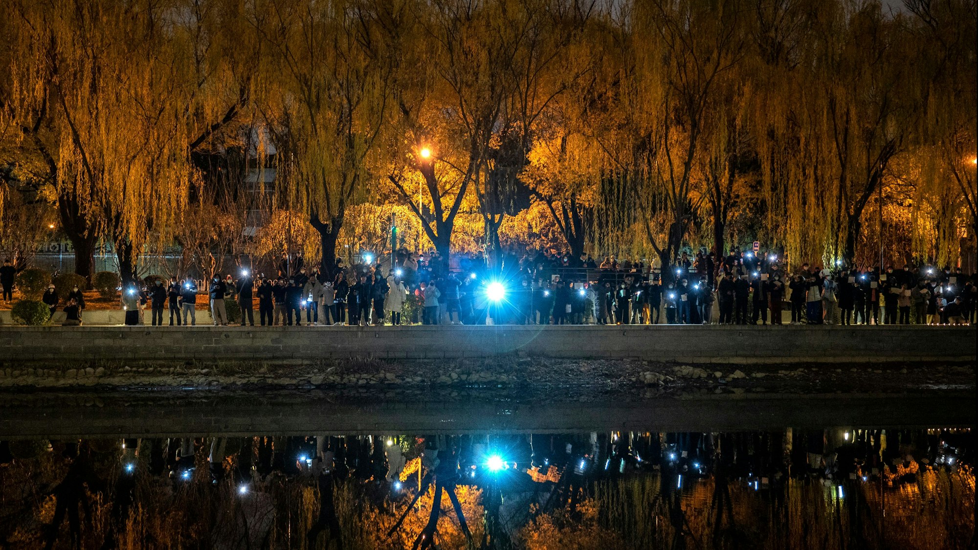 Protestierende in Peking halten ihre Handys in die Luft.