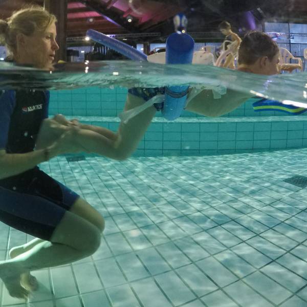 Das Bild zeigt Simone Schridde im Wasser mit einem Schwimmschüler.