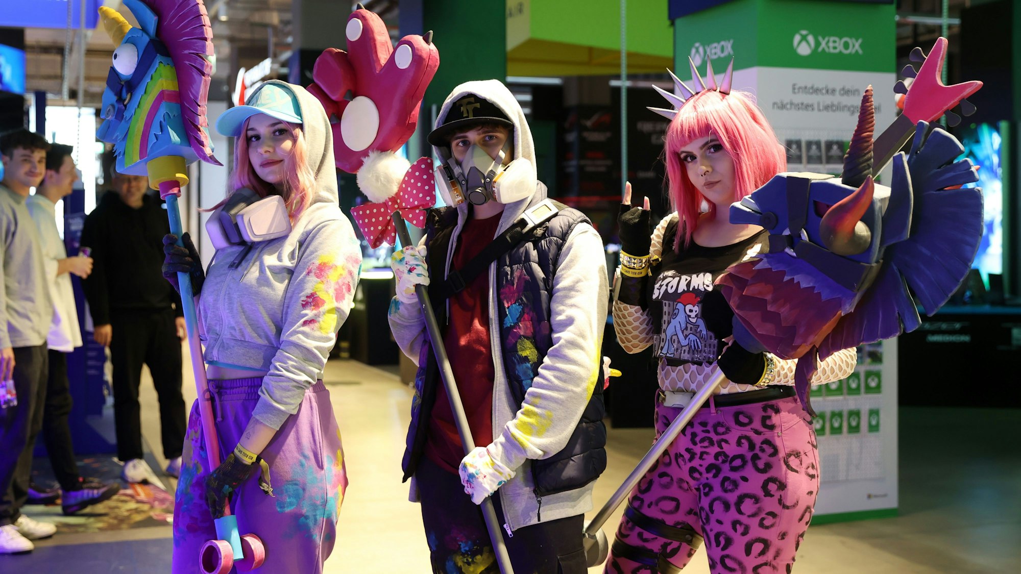 Das Bild zeigt drei Fans, die als Fortnite-Figuren verkleidet sind: Alina Müller als Teknique, Daniel Föll als Abstract und Annika Heinrichs als Powercord.