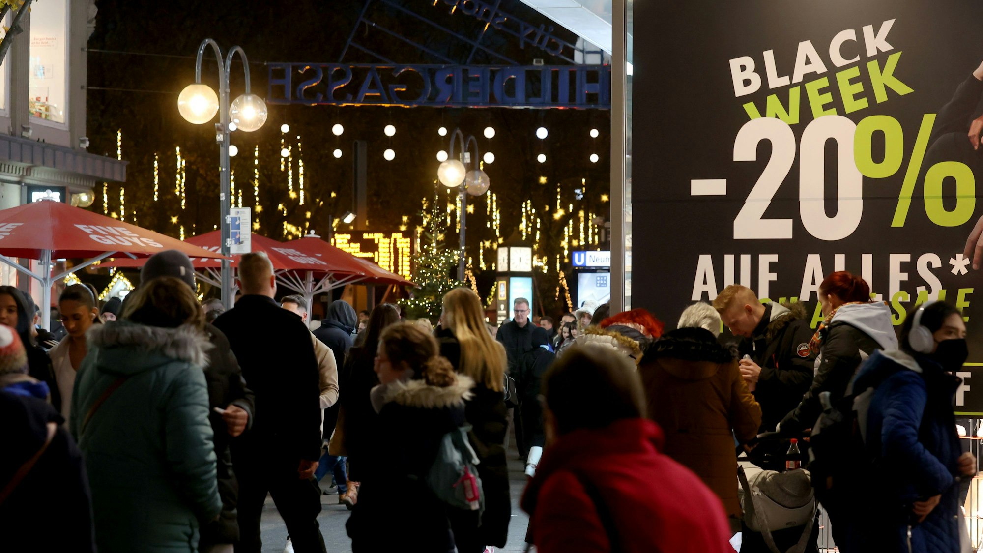Viele Leute tummeln sich am frühen Abend auf der beleuchteten Schildergasse.