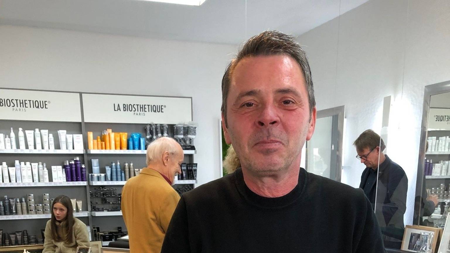 Friseurmeister Ralph Schwalbach steht in seinem Salon an der Luxemburger Straße und hält eine Kanne aus Silber in der Hand.