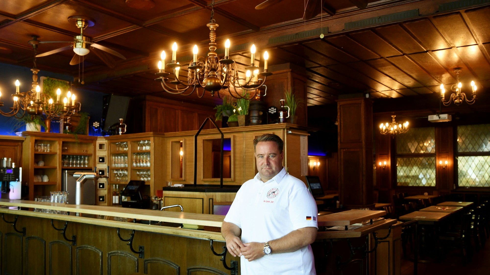 Der Chef des Restaurants Haus Unkelbach in Köln steht vor der Theke des Lokals.