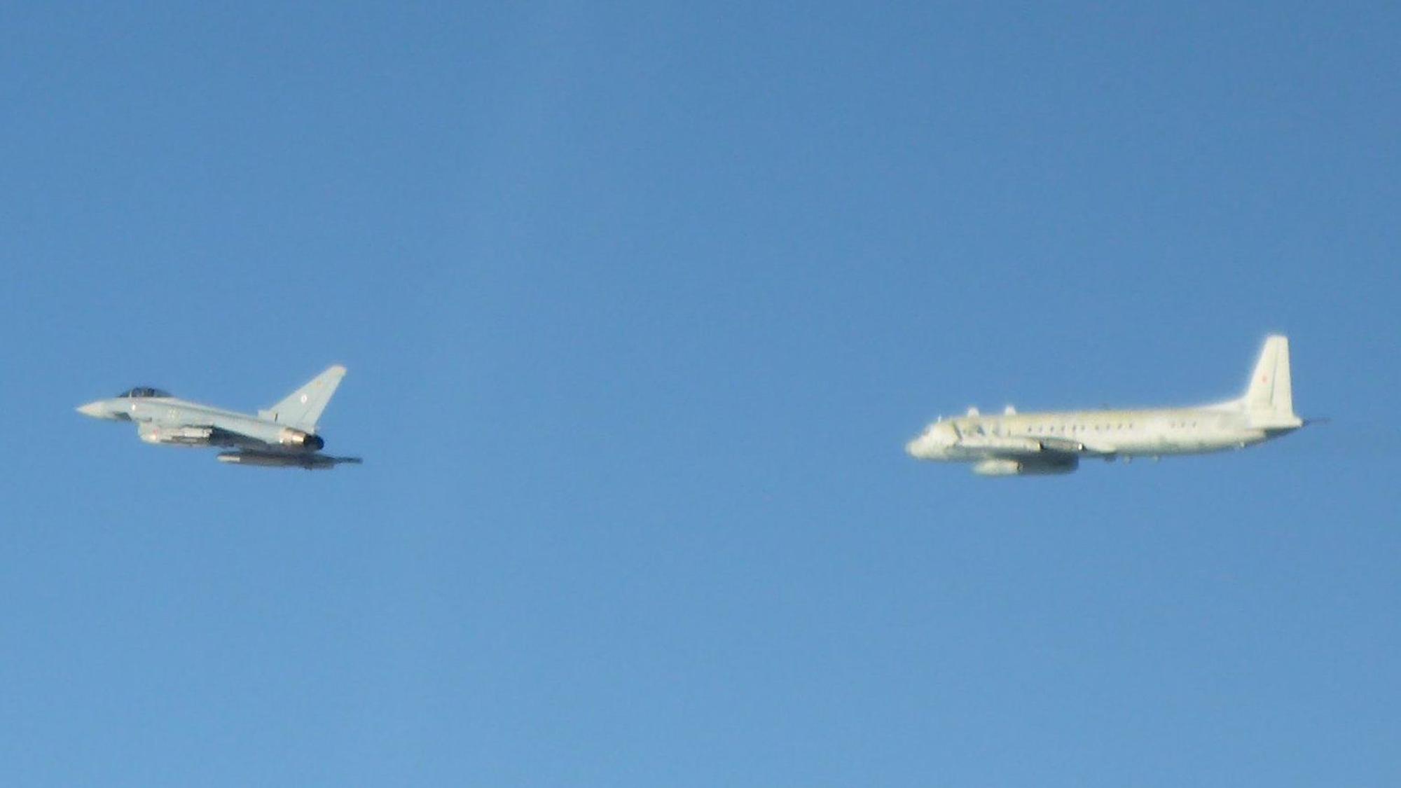 Ein Eurofighter der Alarmrotte der deutschen Luftwaffe (l.) überprüft über der Ostsee ein russisches Militärflugzeug vom Typ Iljuschin IL-20.
