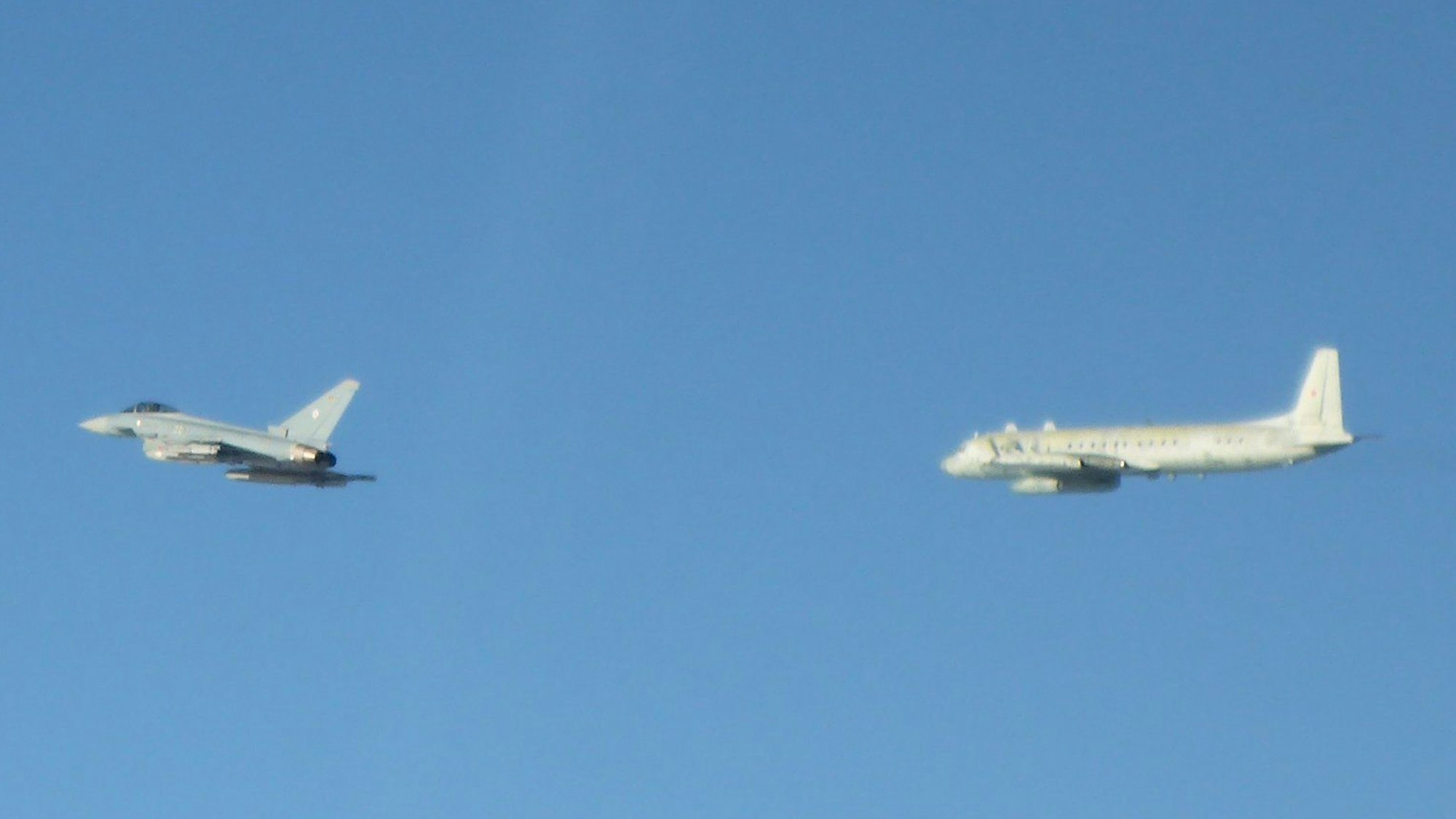 Ein Eurofighter der Alarmrotte der deutschen Luftwaffe (l.) überprüft über der Ostsee ein russisches Militärflugzeug vom Typ Iljuschin IL-20.
