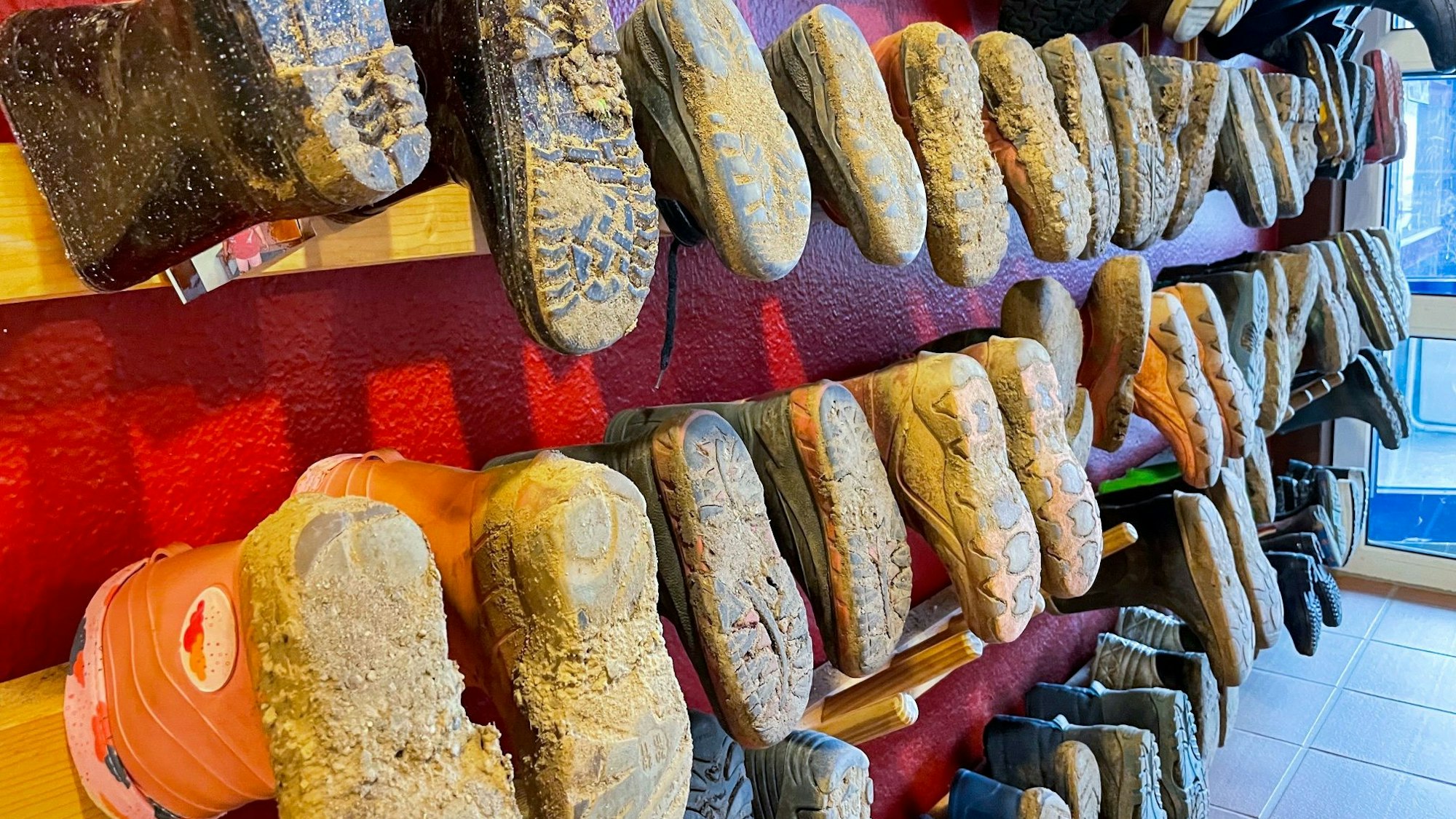 Zahlreiche schmutzige Kinderschuhe sind in einer Kita im Kreis Euskirchen aufgereiht.