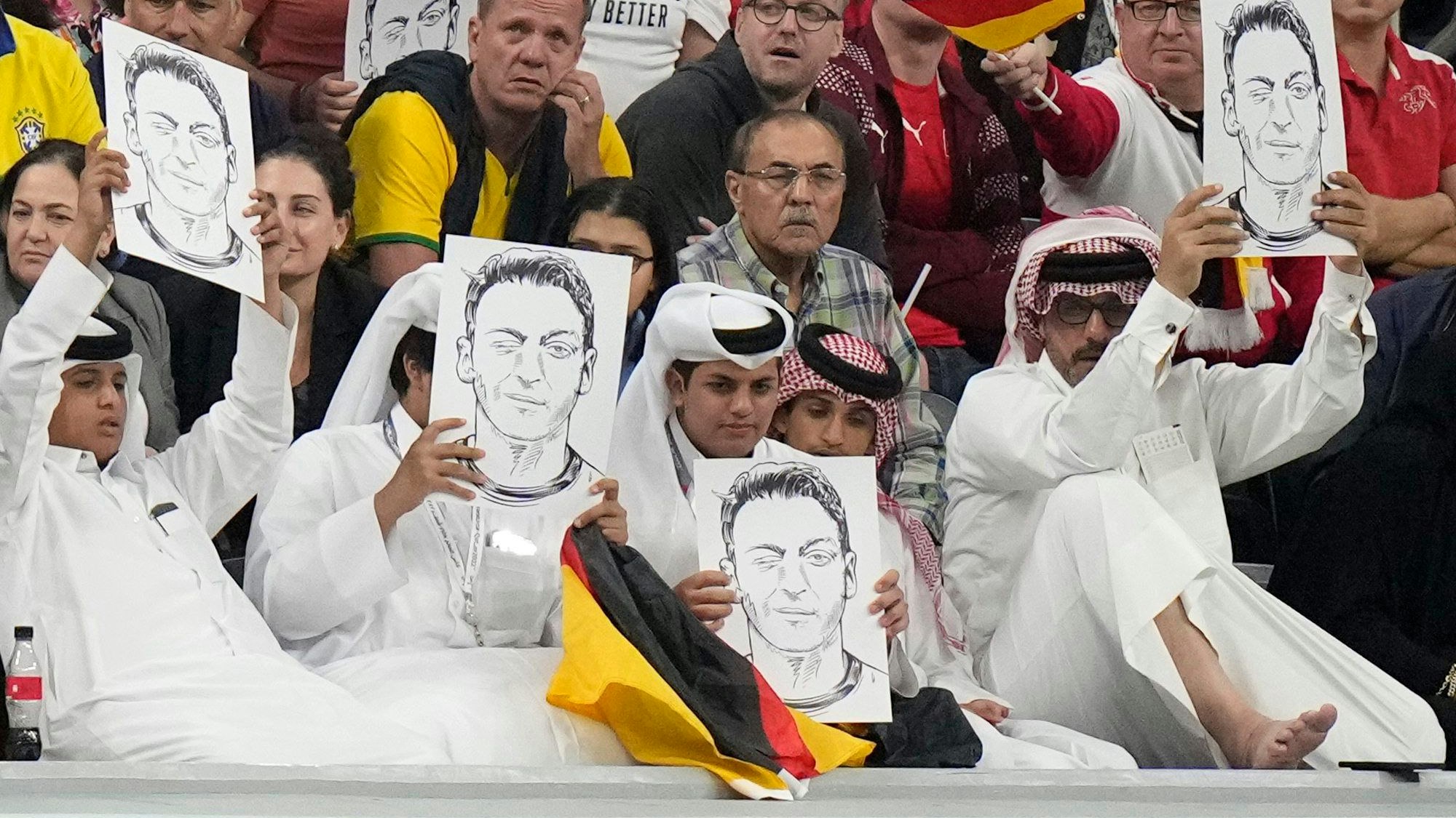 Offensichtlich katarische Zuschauer halten im Al-Bayt-Stadion am Sonntagabend bei der Partie zwischen Deutschland und Spanien Portraits von Mesut Özil in die Höhe.