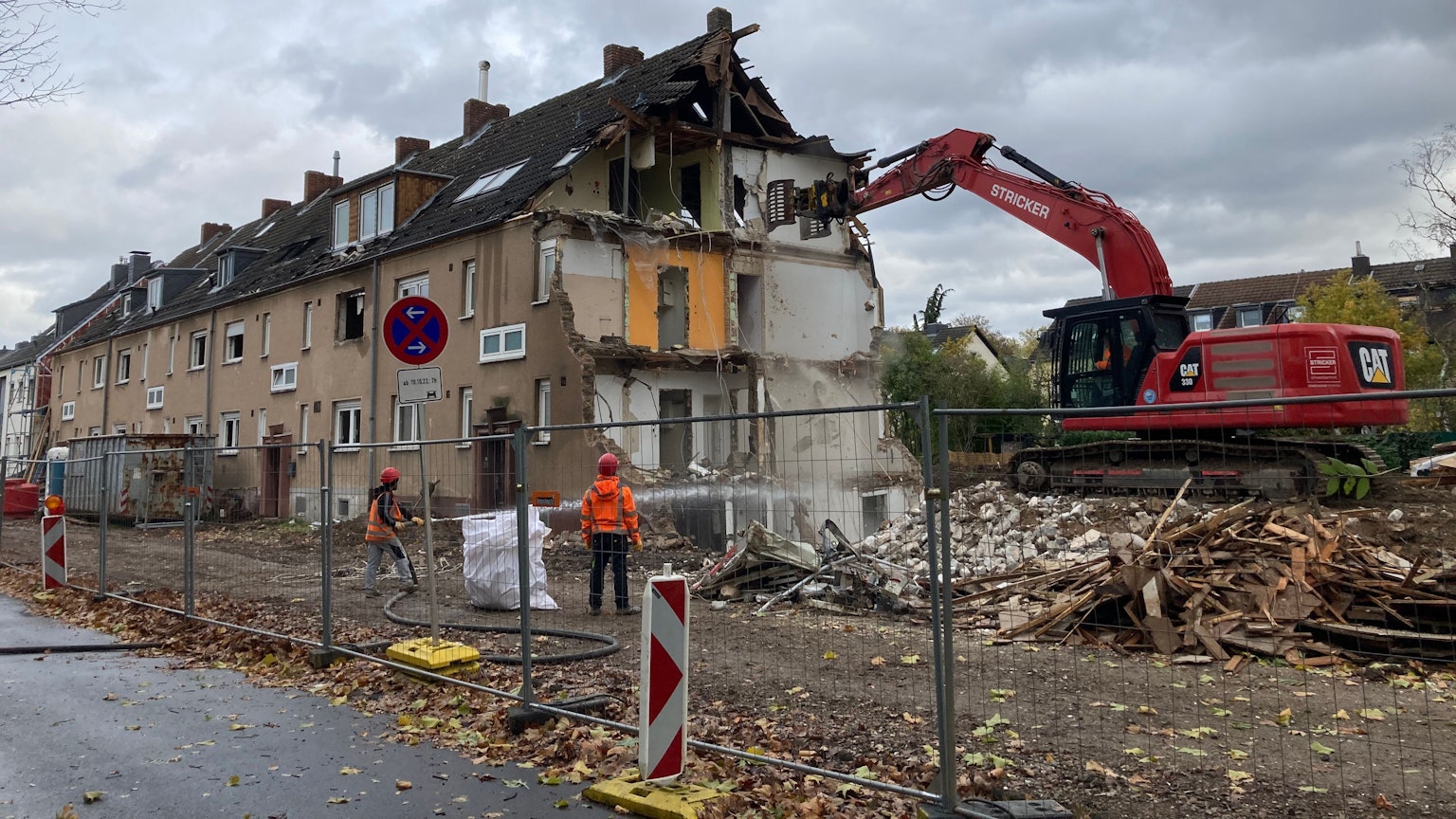Abbrucharbeiten in Ossendorf: Ein Bagger steht auf einem Schuttberg und reißt eine Hauswand ein.