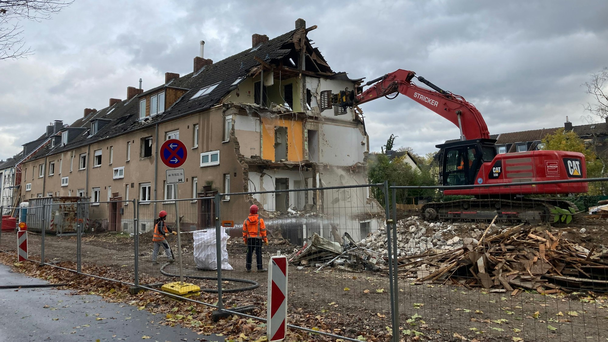 Abbrucharbeiten in Ossendorf: Ein Bagger steht auf einem Schuttberg und reißt eine Hauswand ein.