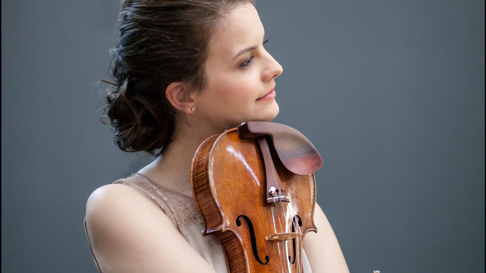Violinistin Veronika Eberle hält ihre Geige eng an ihrem Körper und stützt sich mit ihrem Kinn auf sie.