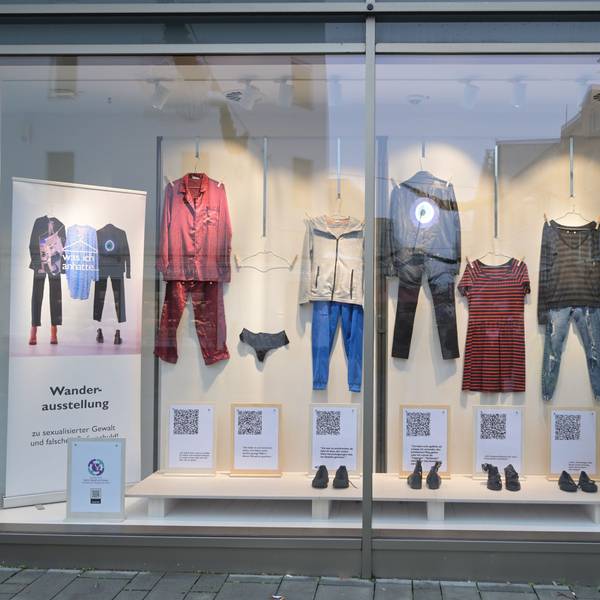 In einem Schaufenster sind verschiedene Kleidungsstücke und Schuhe ausgestellt, die Frauen anhatten, als ihnen Gewalt widerfuhr.