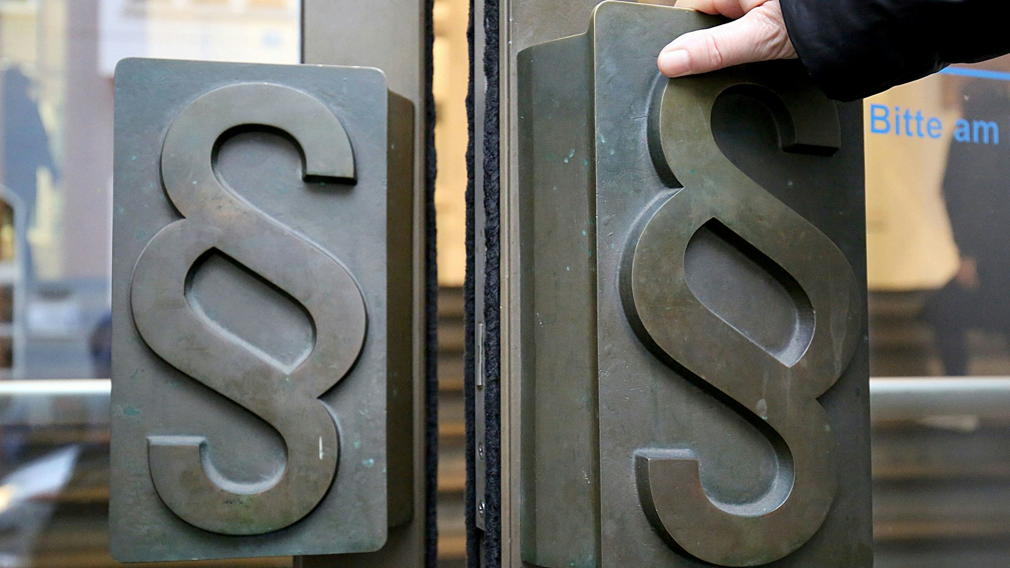 Paragrafen-Symbole sind an Türgriffen am Eingang zum Landgericht angebracht.