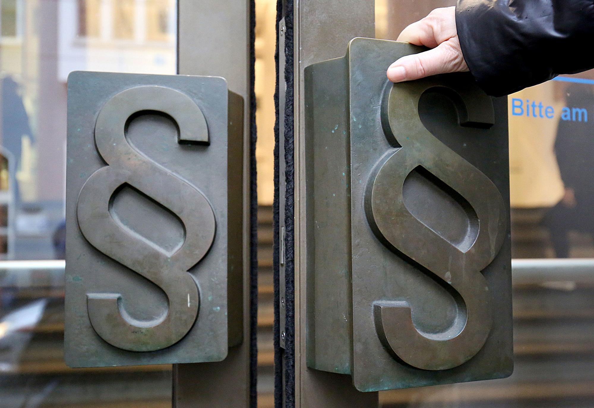 Paragrafen-Symbole sind an Türgriffen am Eingang zum Landgericht angebracht.