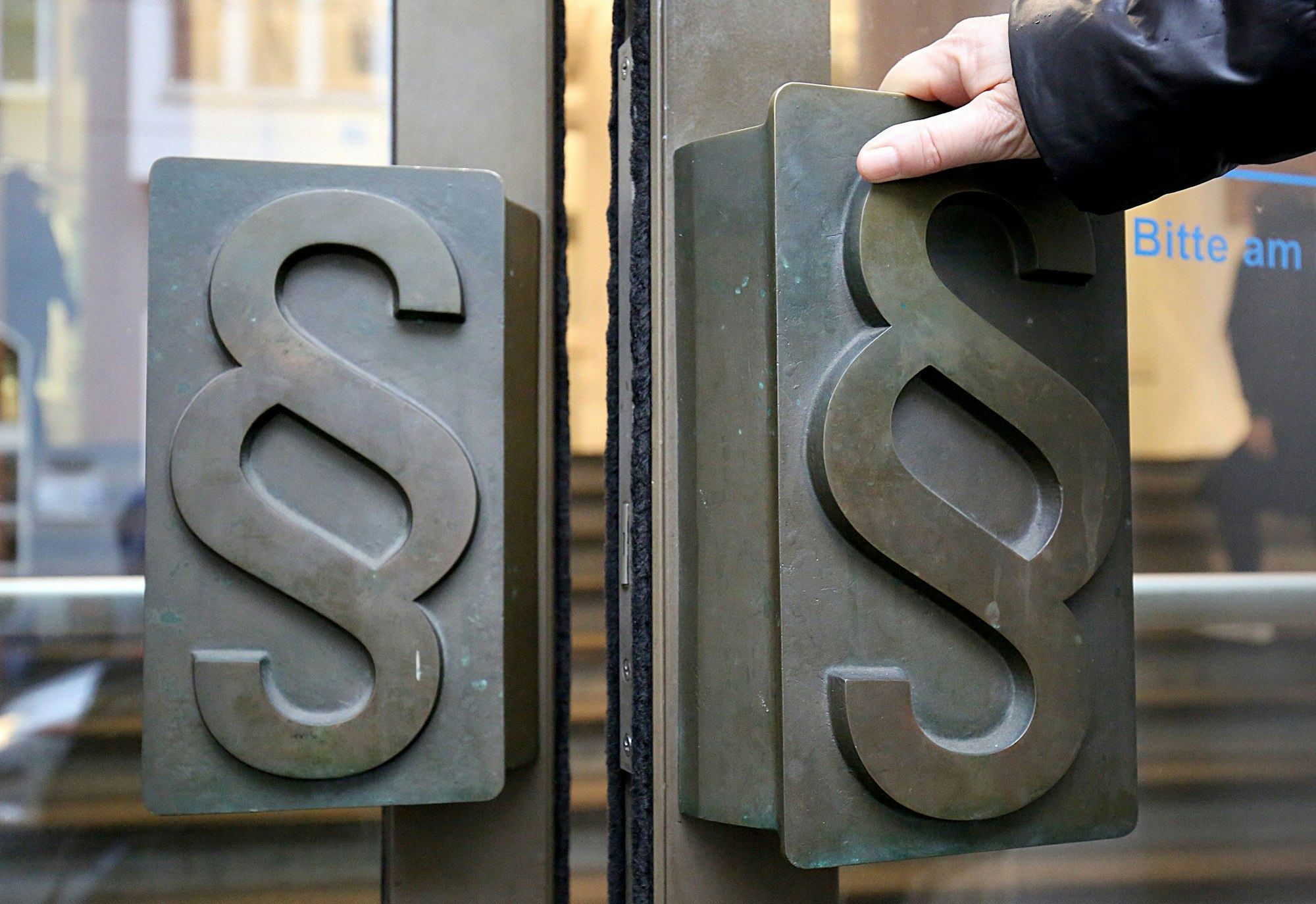 Paragrafen-Symbole sind an Türgriffen am Eingang zum Landgericht angebracht.