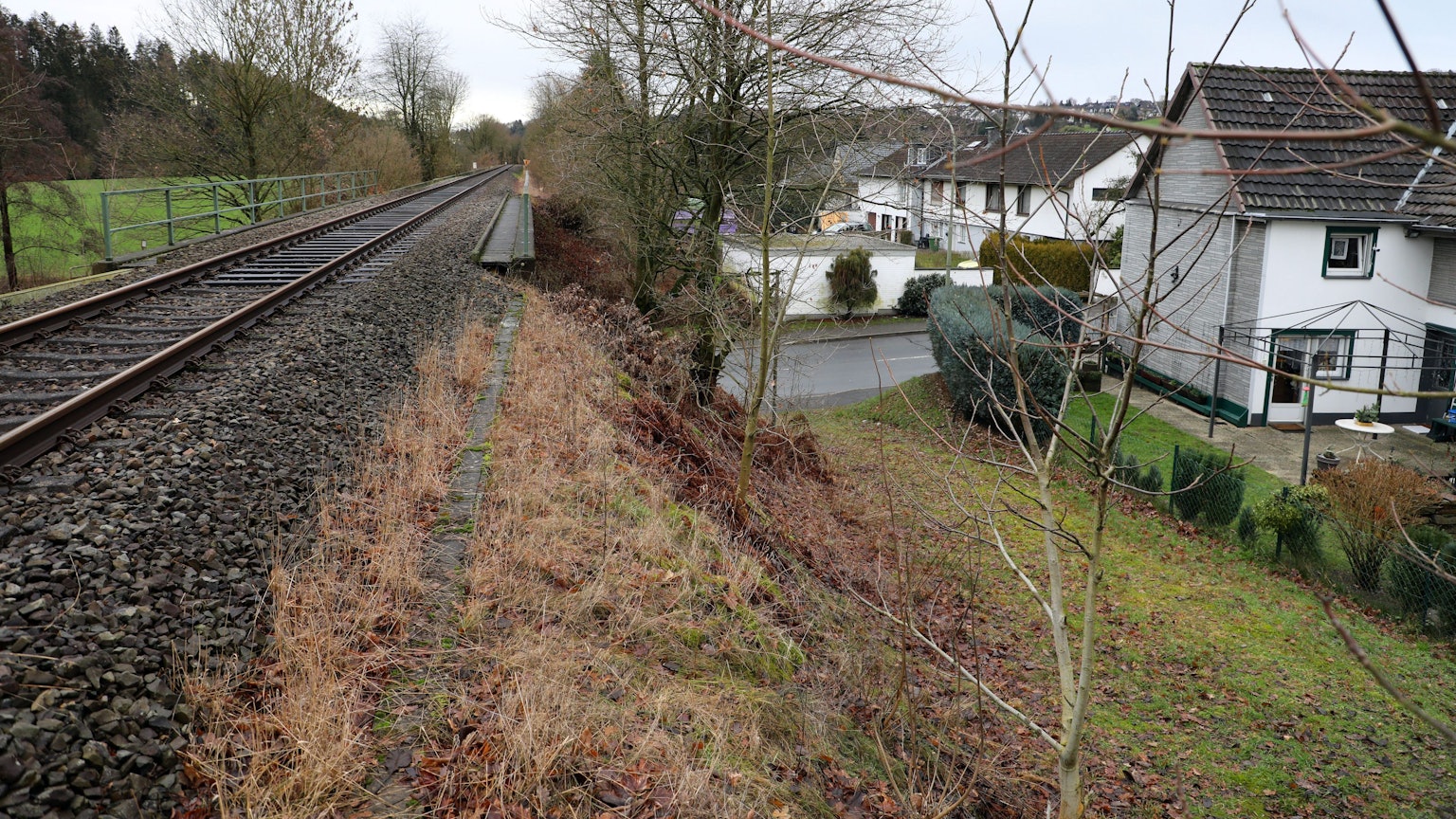 Blick auf Vilkerath: Links eine Schienentrasse, rechts ein Wohngebiet.