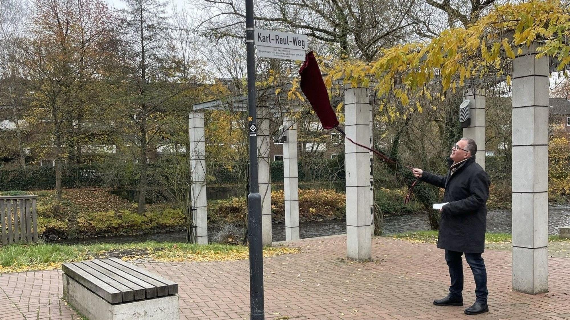 Leichlingens Bürgermeister Frank Steffes enthüllt das Schild „Karl-Reul-Weg“.