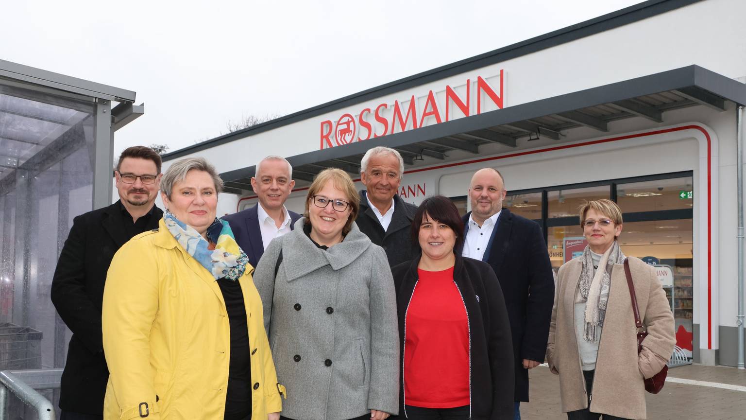 Männer und Frauen stehen vor einem Drogeriemarkt in Bergneustadt.