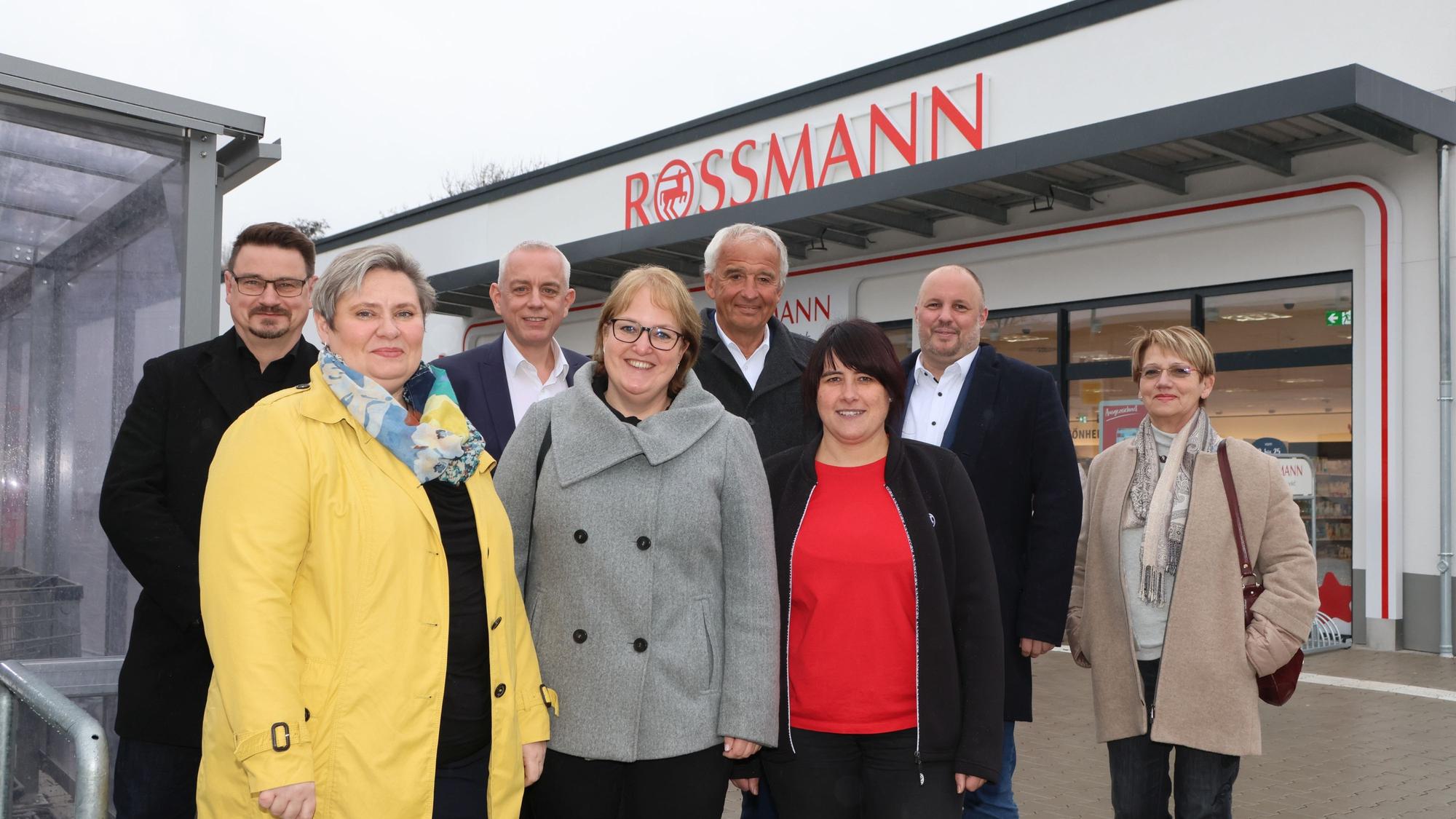 Männer und Frauen stehen vor einem Drogeriemarkt in Bergneustadt.