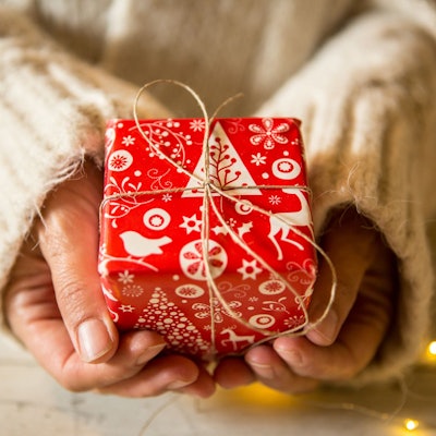 Hände halten ein Weihnachtsgeschenk