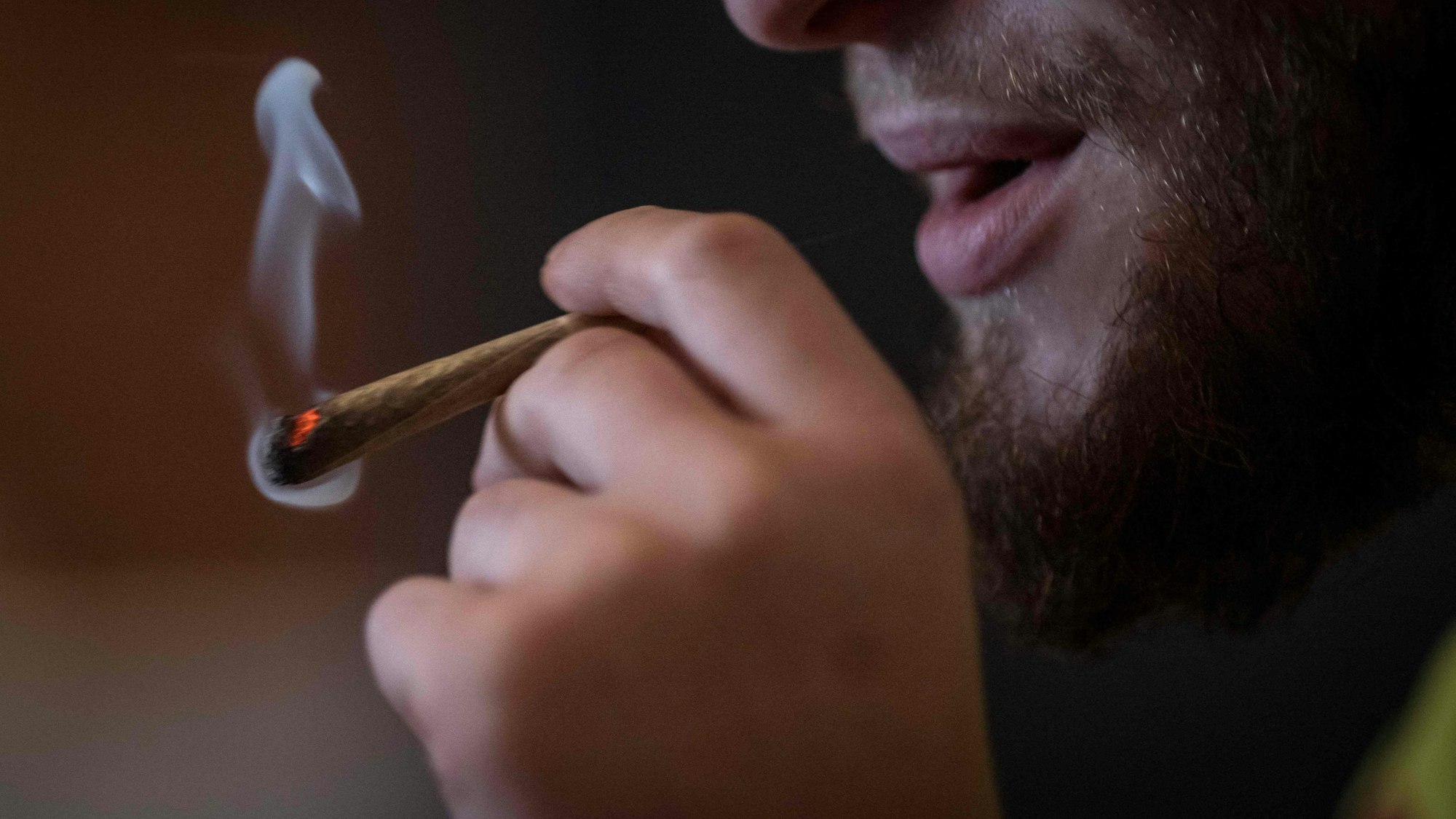 Ein Mann raucht einen Joint.