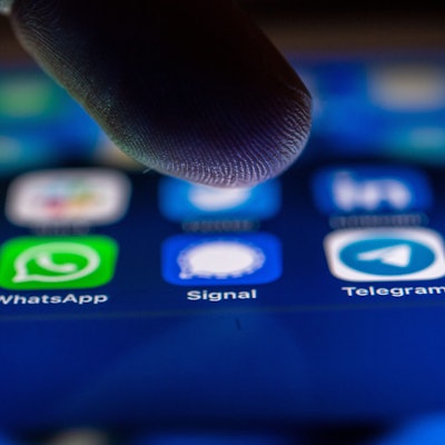 Ein Finger tippt auf einen erleuchteten Handybildschirm.