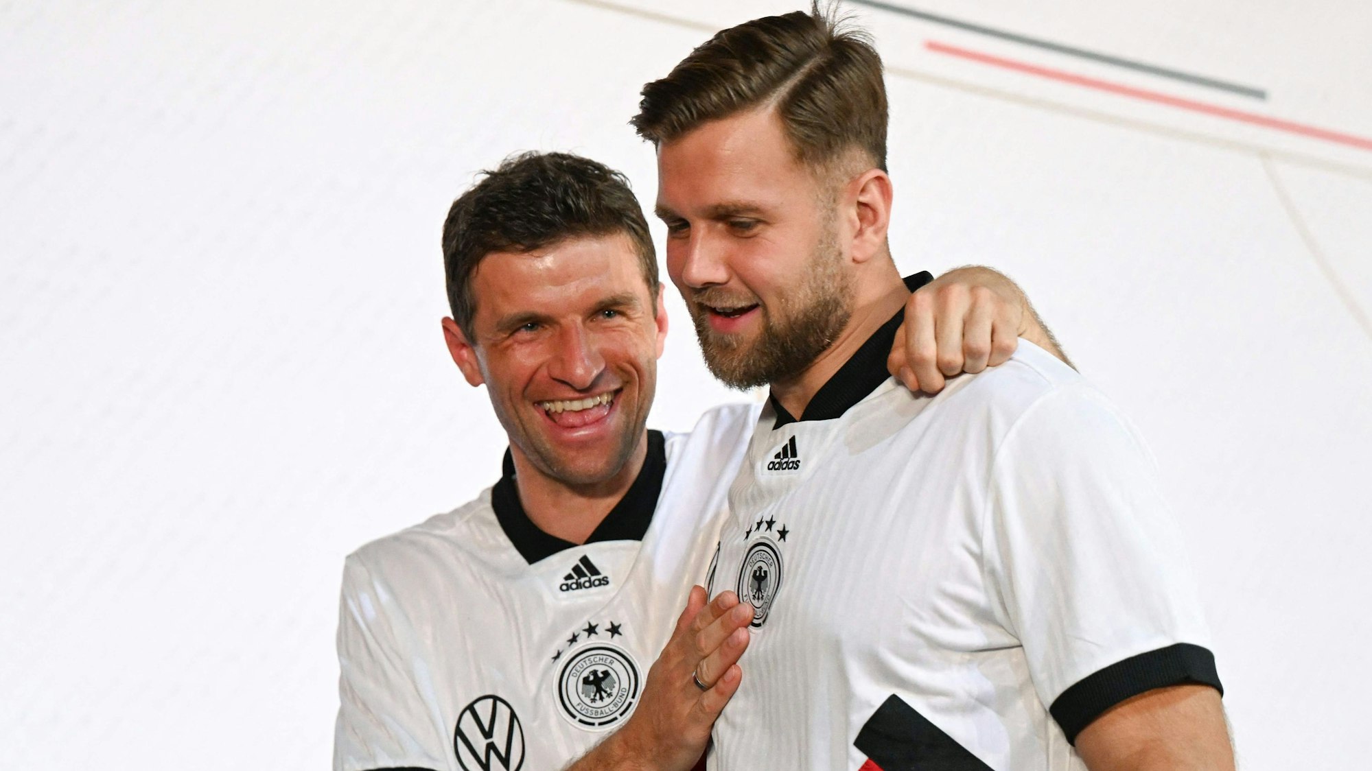 Die Nationalspieler Thomas Müller (r.) und Niclas Füllkrüg (l.) auf dem Weg zur Pressekonferenz der deutschen Nationalmannschaft in Doha. Müller schüttelt Füllkrug an den Schultern durch.