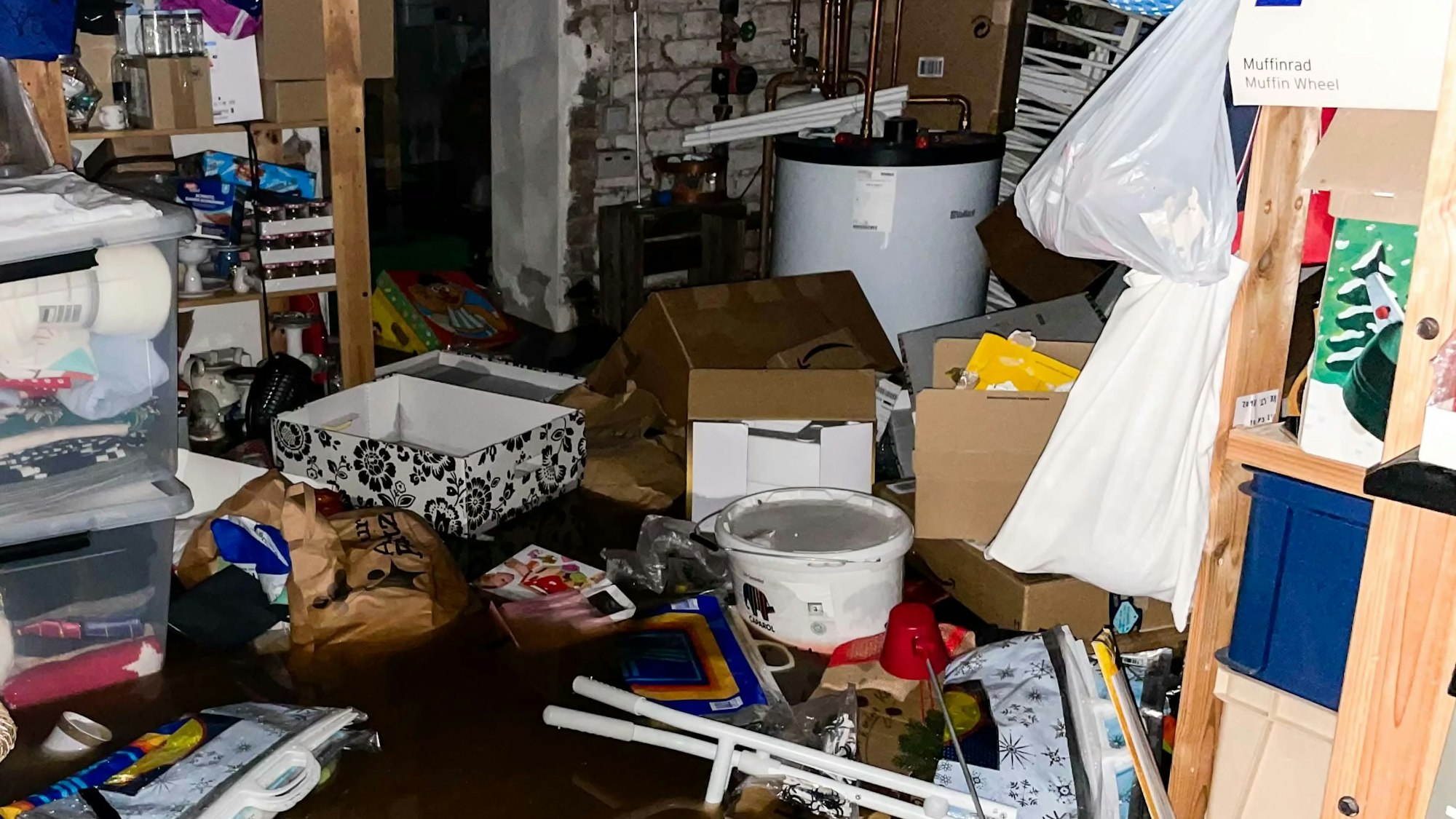 In einem dunklen Raum im Kreis Euskirchen schwimmen Kisten und Tüten im Wasser.